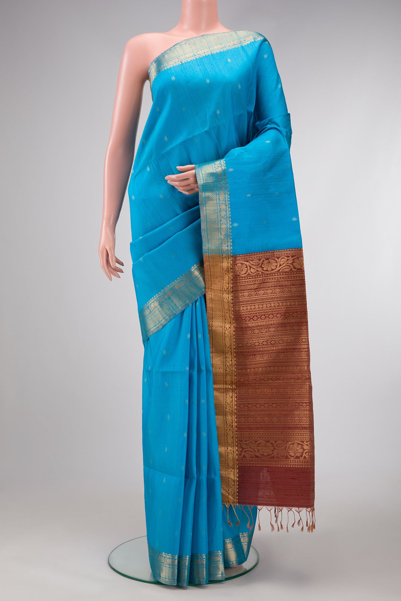 Sky Blue Dual Tone Raw Silk Saree with Zari Butta on the body and Zari Border.  displayed on a mannequin