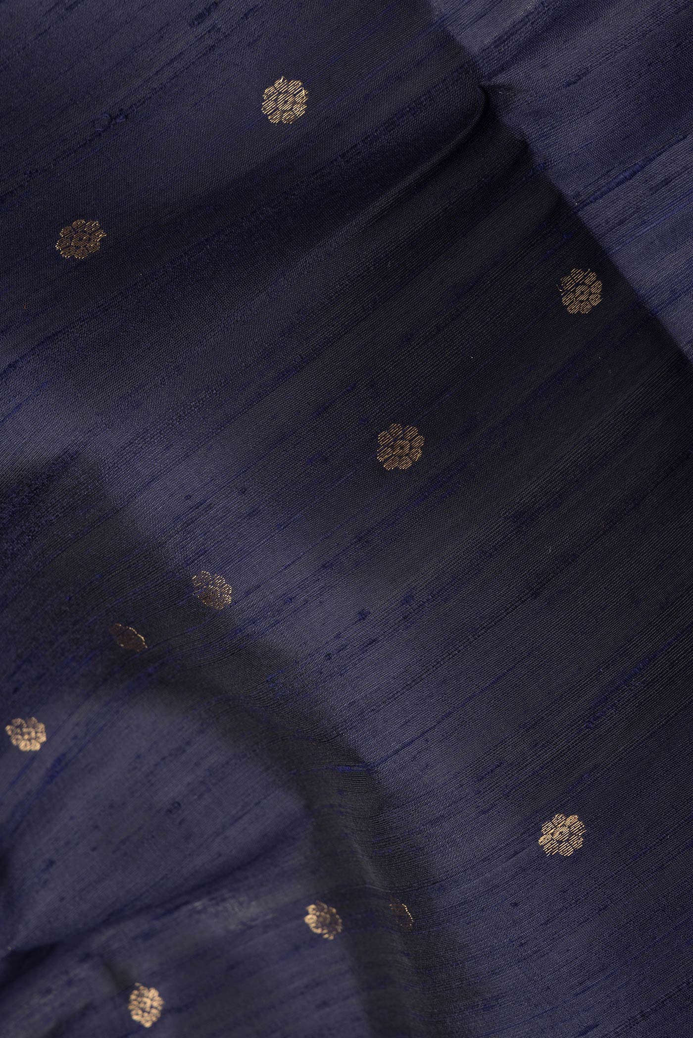 Close up of Navy Blue Dual Tone Raw Silk Saree with Zari Butta on the body and Zari Border.  displaying folds