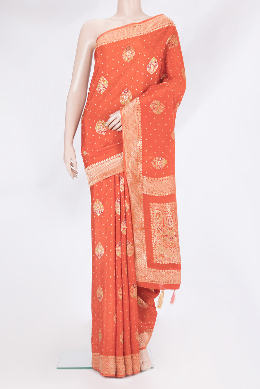 Brick Orange Blended Banarasi Silk Saree with Zari And Thread Butta on the body and Zari Border.  displayed on a mannequin