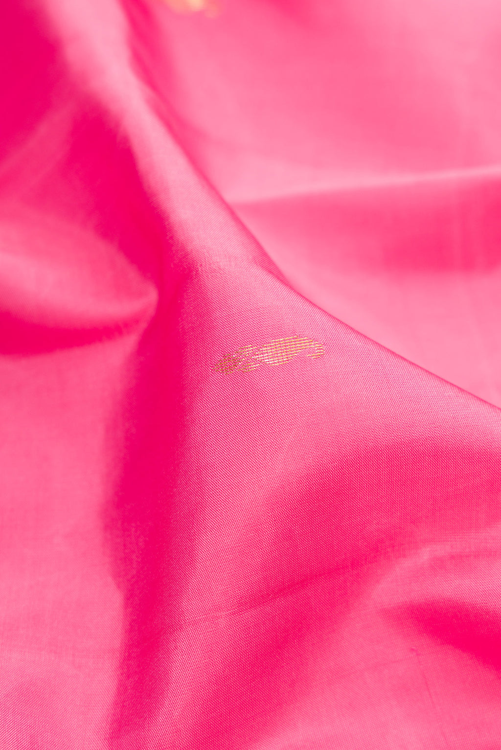 Close up of Pink Kanjivaram Silk Saree with Zari Butta on the body and Zari Border.  displaying folds
