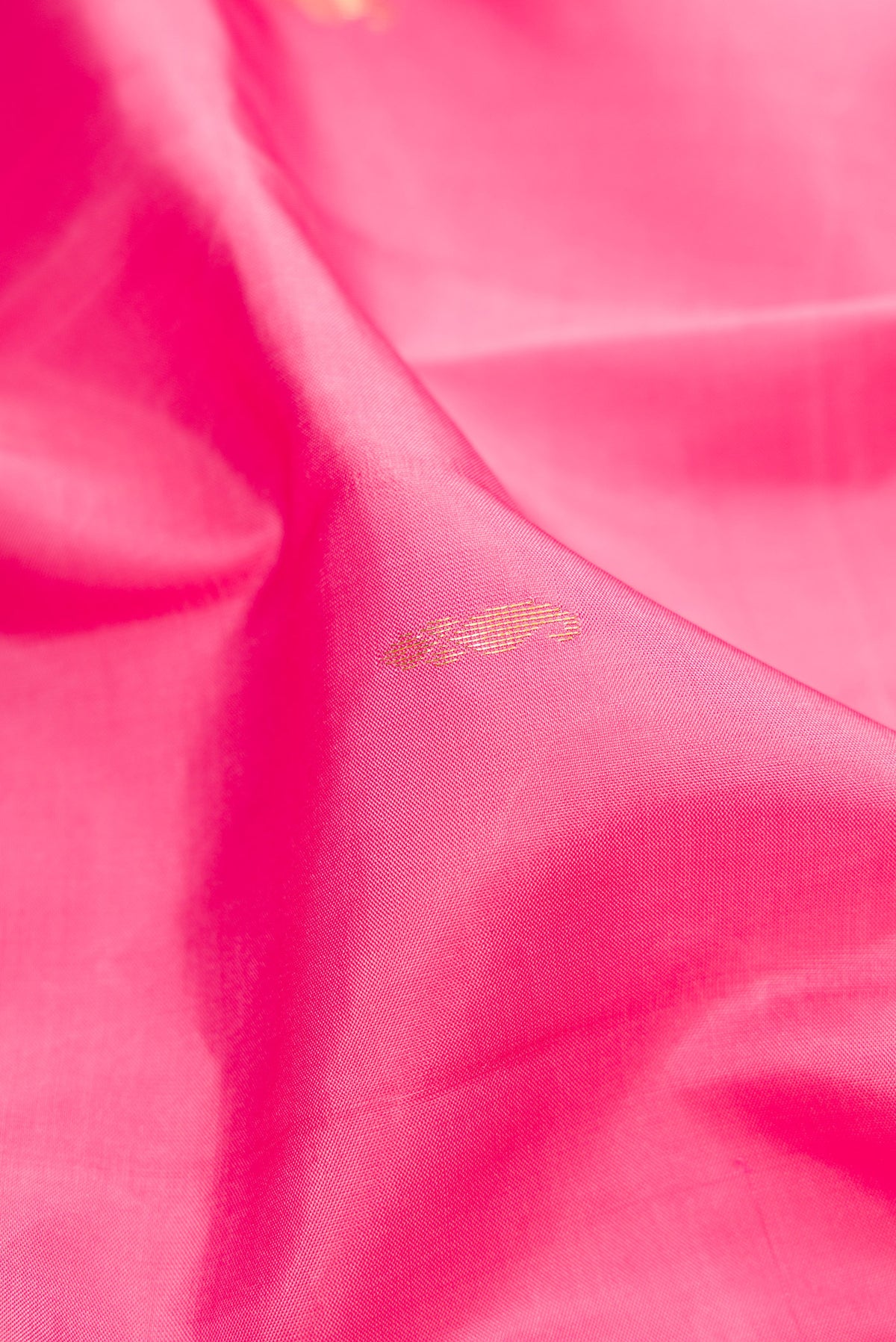 Close up of Pink Kanjivaram Silk Saree with Zari Butta on the body and Zari Border.  displaying folds