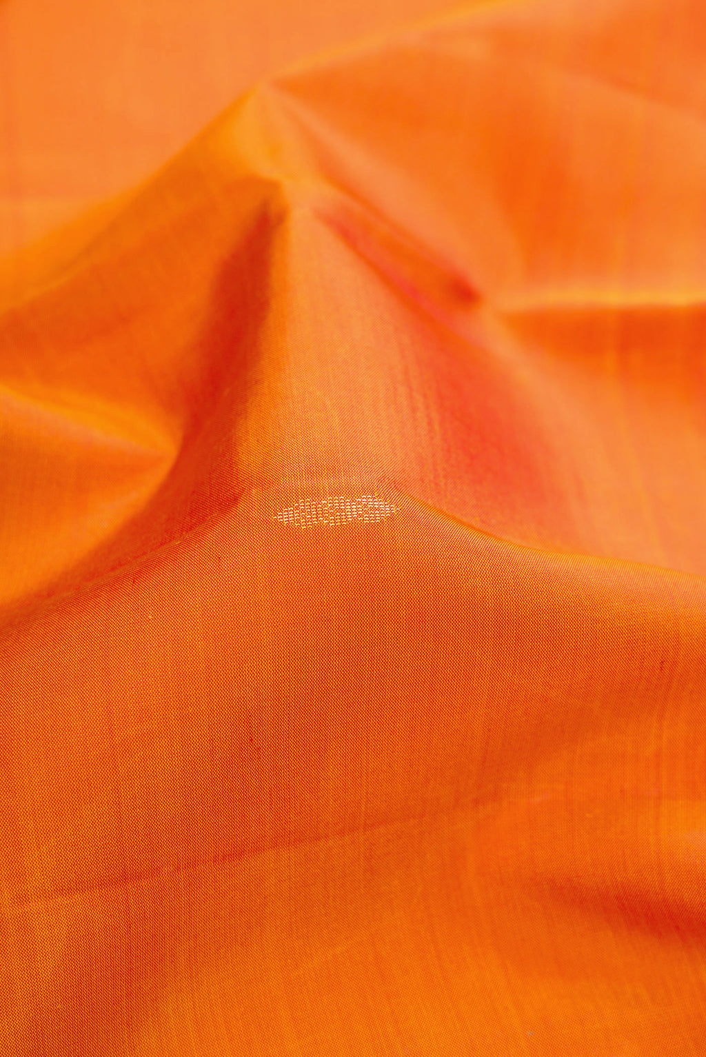 Close up of Orange Dual Tone Soft Silk Saree with Zari Butta on the body and Zari Border.  displaying folds