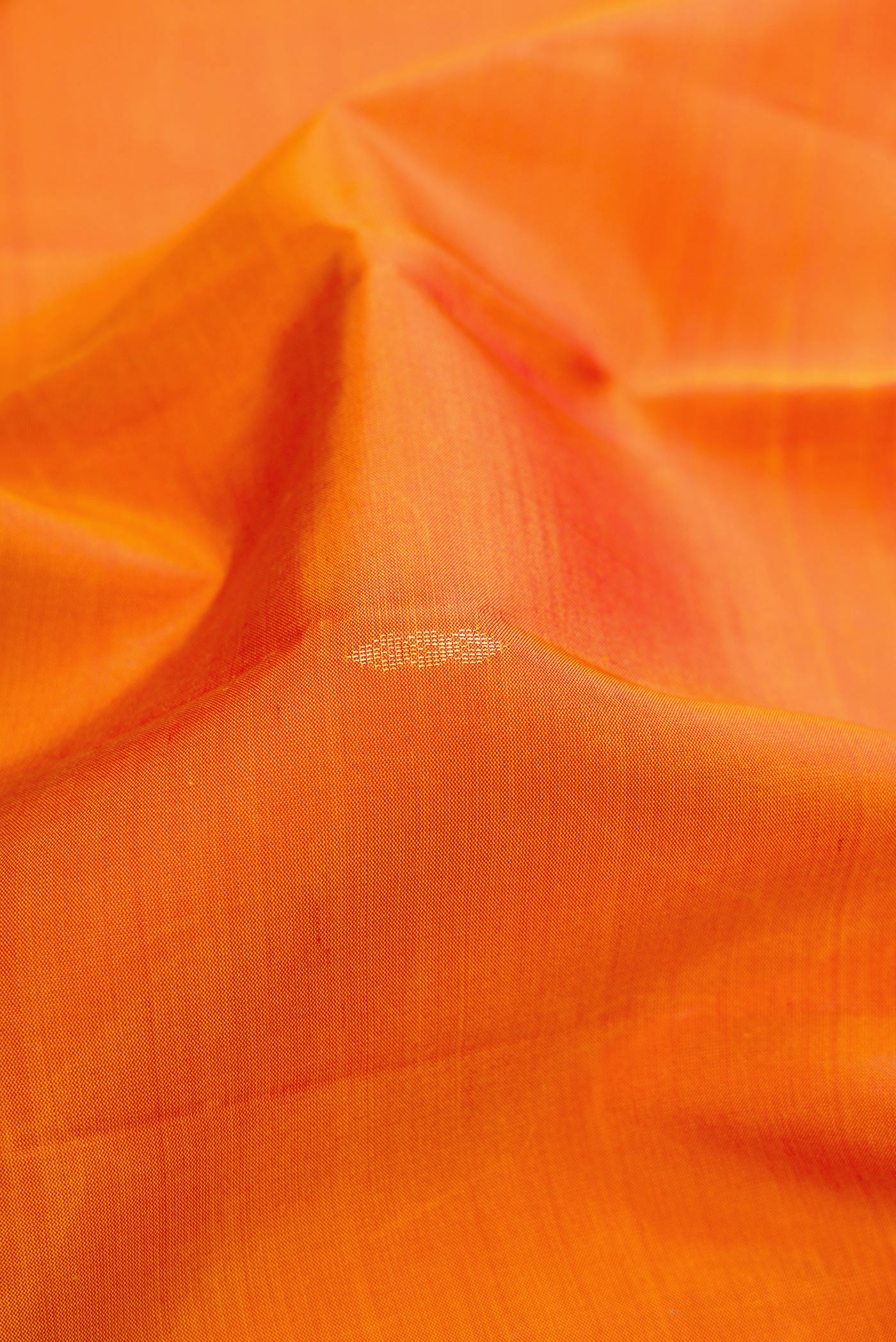 Close up of Orange Dual Tone Soft Silk Saree with Zari Butta on the body and Zari Border.  displaying folds