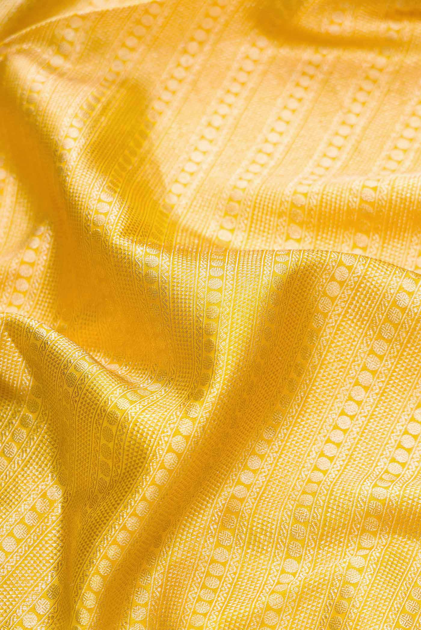 Close up of Yellow Dual Tone Kanjivaram Tissue Silk Saree with Zari Brocade on the body and Zari Border.  displaying folds