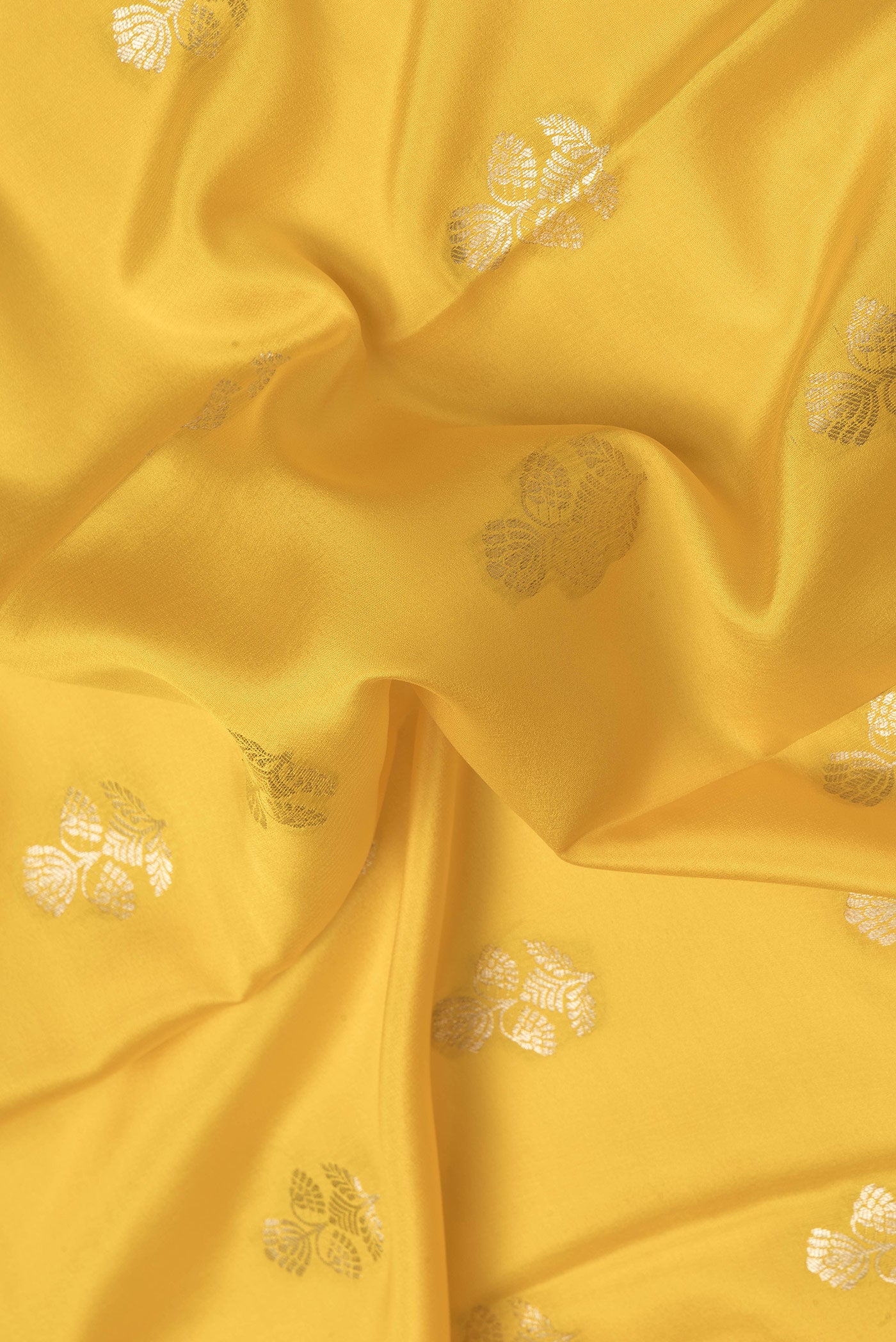 Close up of Yellow Dual Tone Mysore Silk Saree with Zari Butta on the body and Zari Border.  displaying folds