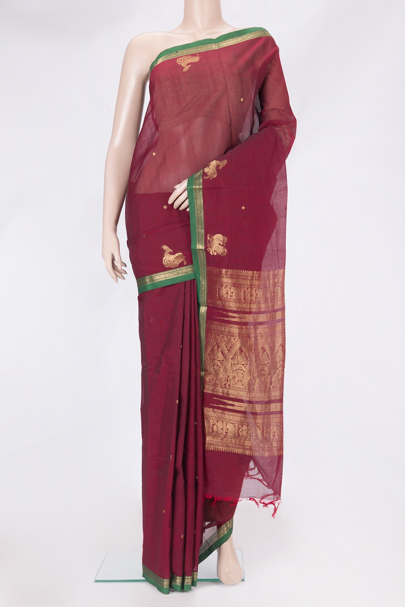 Maroon Kanchi Cotton Saree with Zari Butta on the body and Zari Border.  displayed on a mannequin