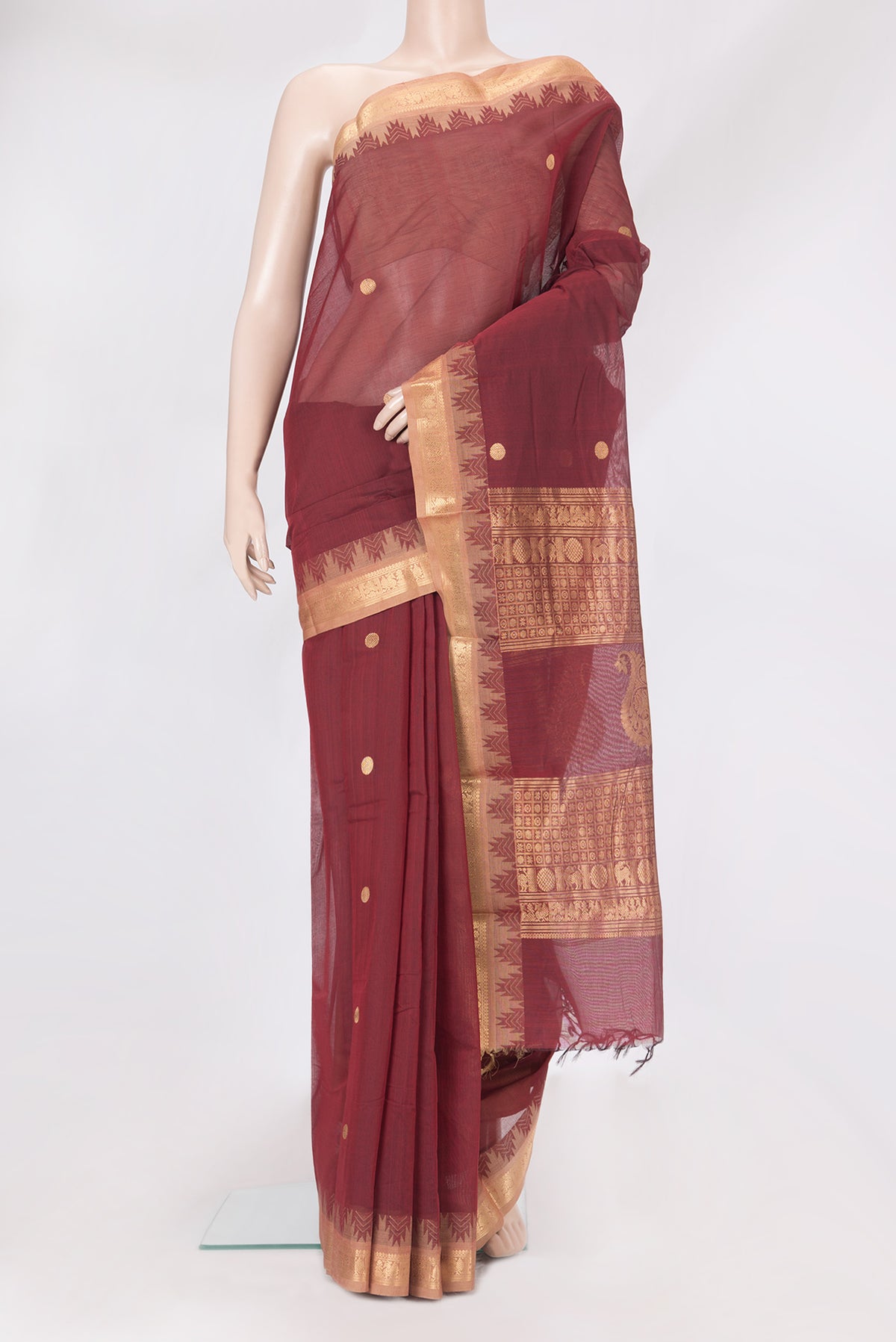 Maroon Kanchi Cotton Saree with Zari Butta on the body and Temple Border.  displayed on a mannequin