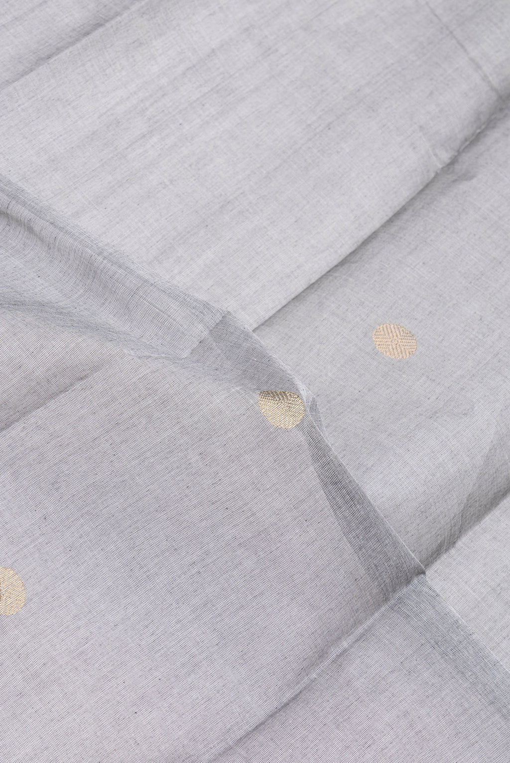 Close up of Grey Kanchi Cotton Saree with Zari Butta on the body and Temple Border.  displaying folds