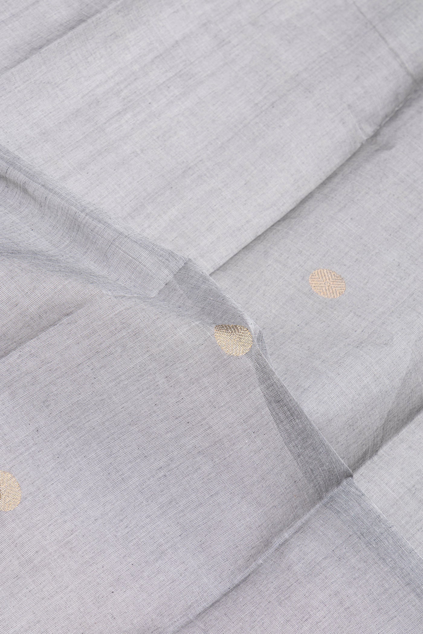 Close up of Grey Kanchi Cotton Saree with Zari Butta on the body and Temple Border.  displaying folds