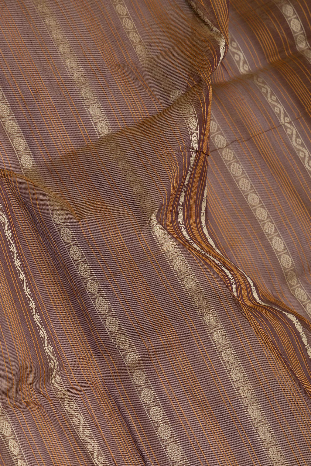 Close up of Brown Kanchi Cotton Saree with Stripes on the body and Zari Border.  displaying folds