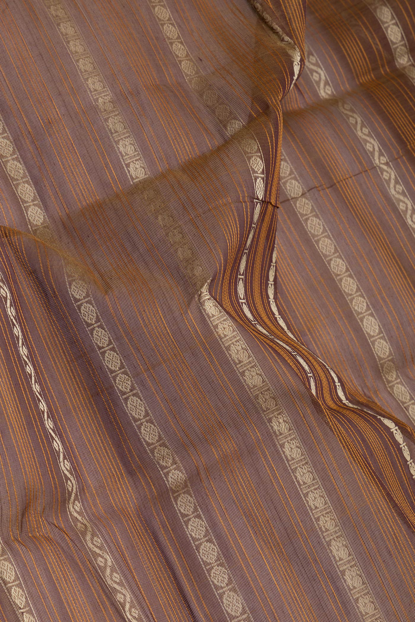 Close up of Brown Kanchi Cotton Saree with Stripes on the body and Zari Border.  displaying folds