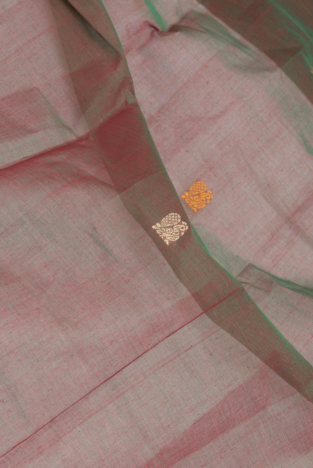 Close up of Green Dual Tone Kanchi Cotton Saree with Thread Butta on the body and Thread Border.  displaying folds