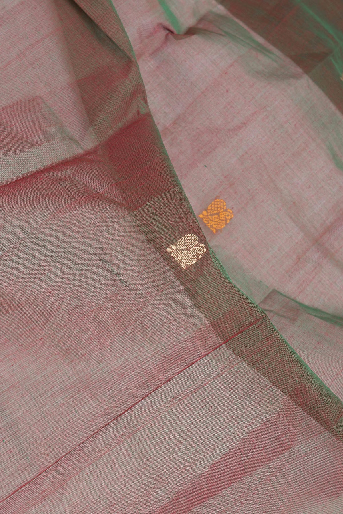 Close up of Green Dual Tone Kanchi Cotton Saree with Thread Butta on the body and Thread Border.  displaying folds