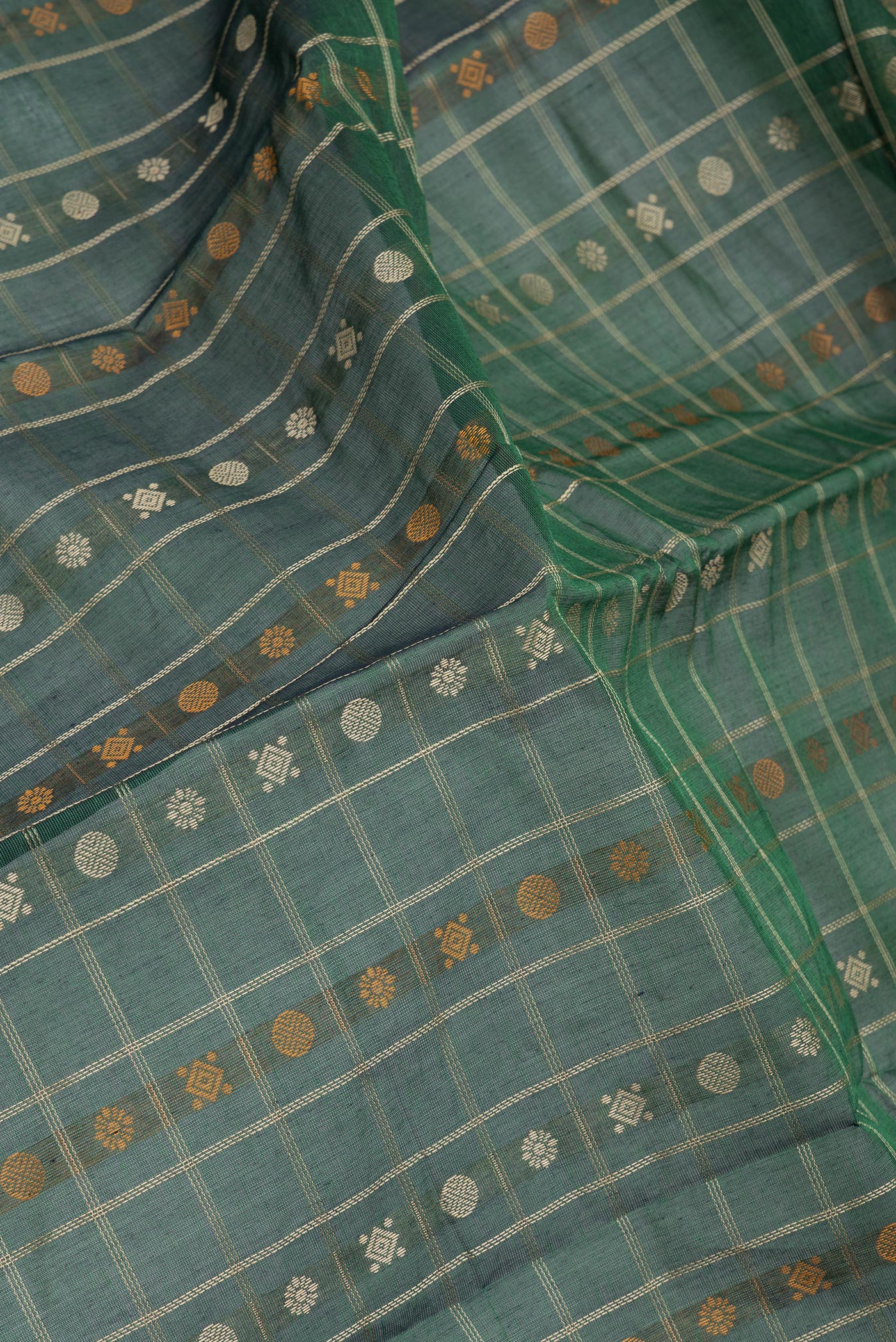 Close up of Bottle Green Kanchi Cotton Saree with Checked design on the body and Zari Border.  displaying folds