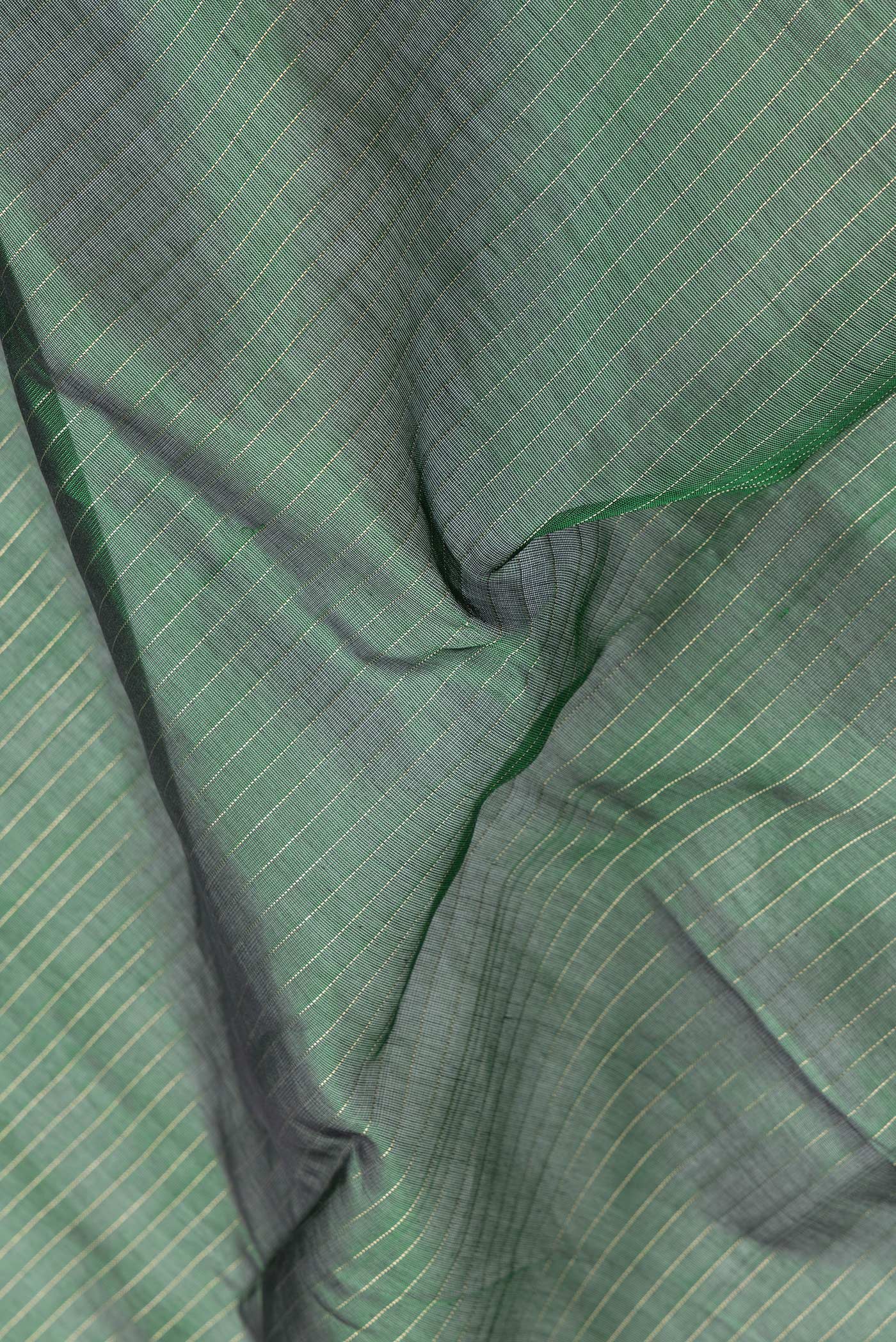 Close up of Green Dual Tone Silk Cotton Saree with Stripes on the body and Zari Border.  displaying folds
