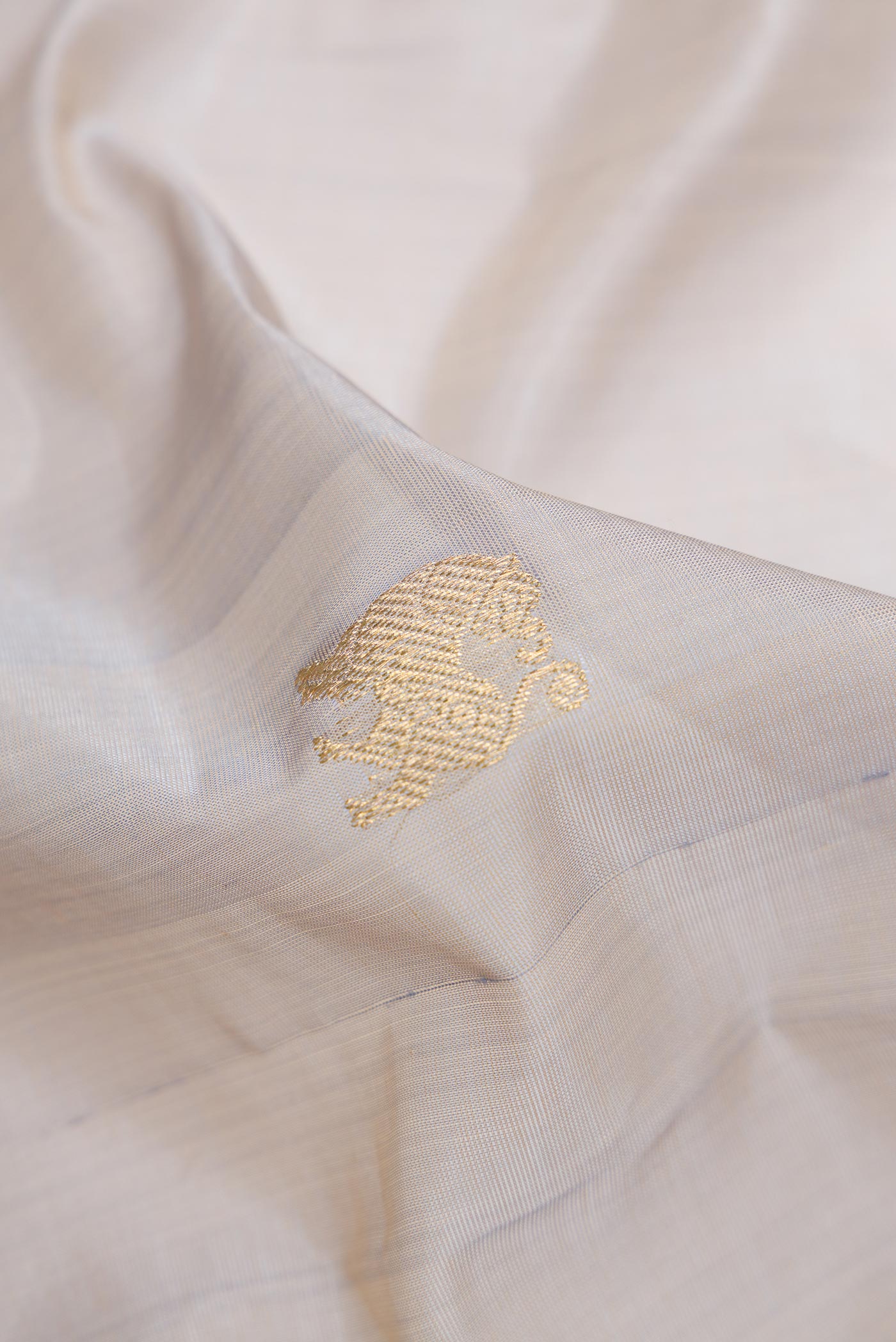 Close up of Grey Dual Tone Silk Cotton Saree with Zari Butta on the body and Zari Border.  displaying folds