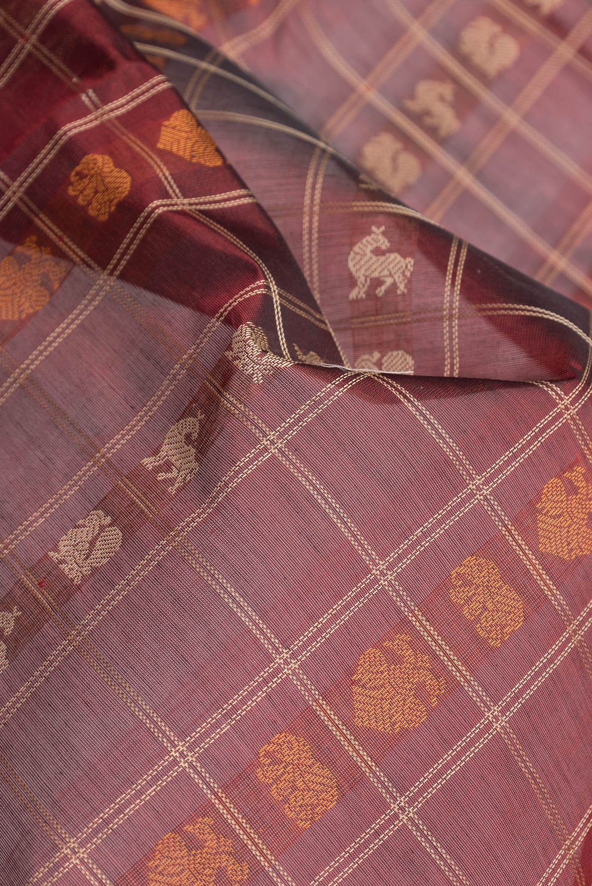 Close up of Maroon Dual Tone Silk Cotton Saree with Checked design on the body and Zari Border.  displaying folds