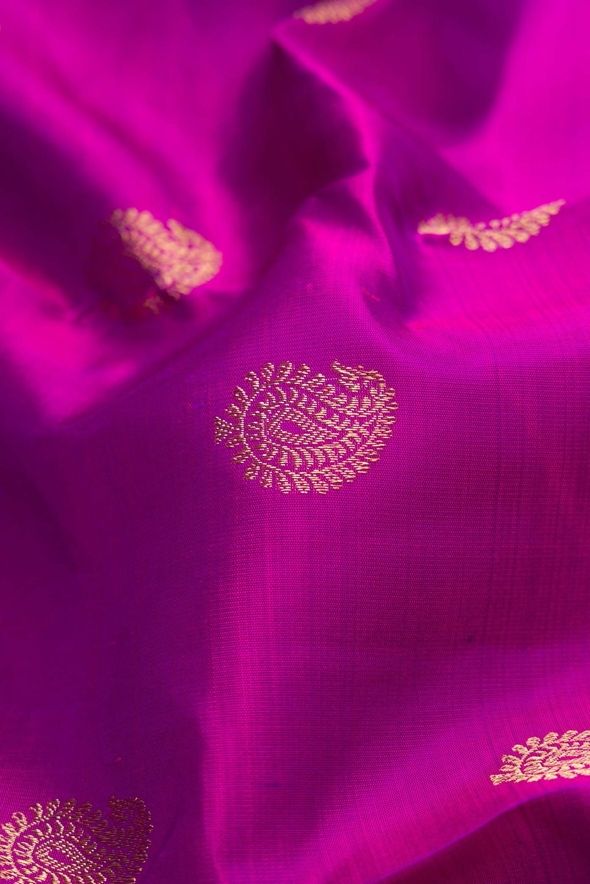 Close up of Pure Silk Pure Zari Purple Dual Tone Kanjivaram Saree with Zari Butta on the body and Zari Border.  displaying folds