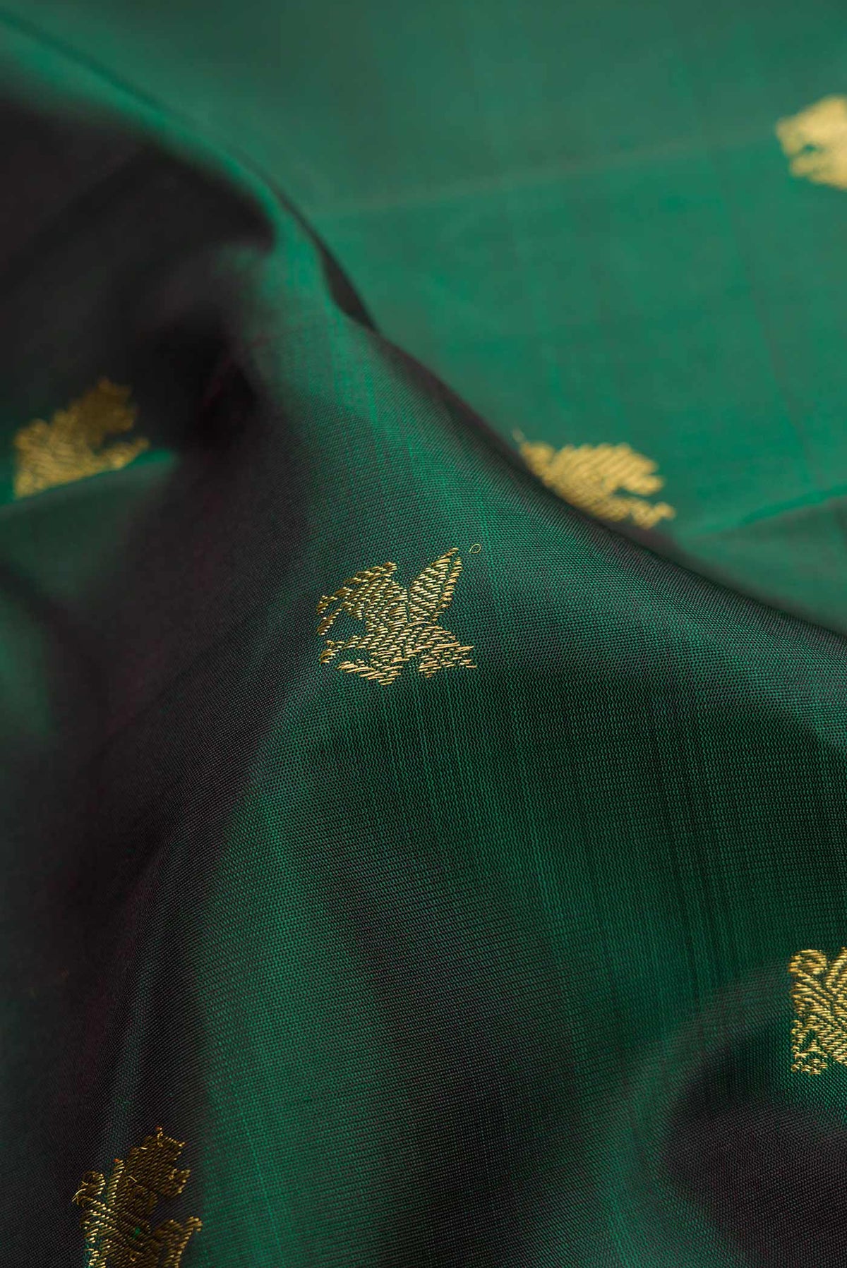 Close up of Pure Silk Pure Zari Bottle Green Dual Tone Kanjivaram Saree with Zari Butta on the body and Zari Border.  displaying folds