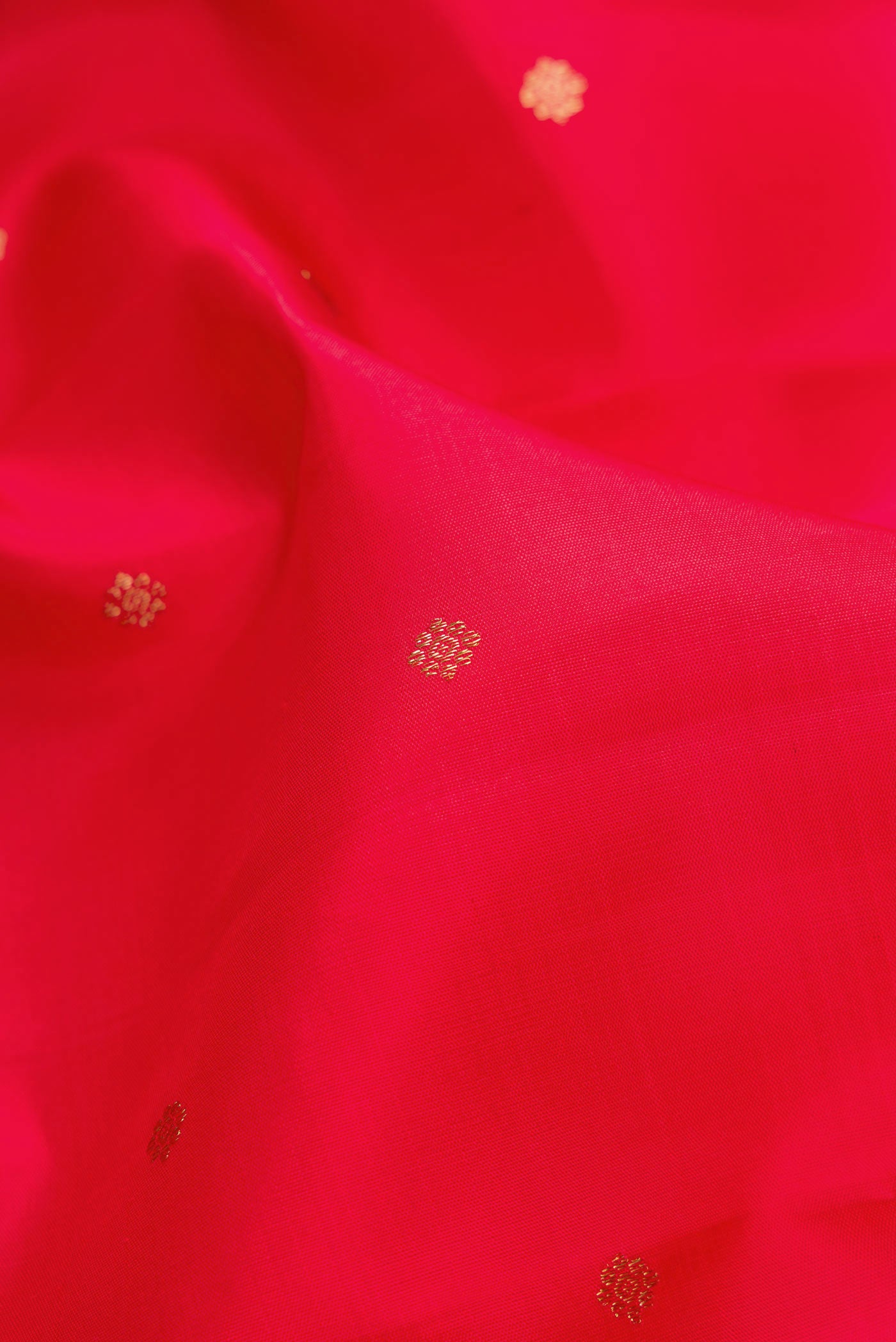 Close up of Pure Silk Pure Zari Red Dual Tone Kanchipuram Saree with Zari Butta on the body and Zari Border.  displaying folds