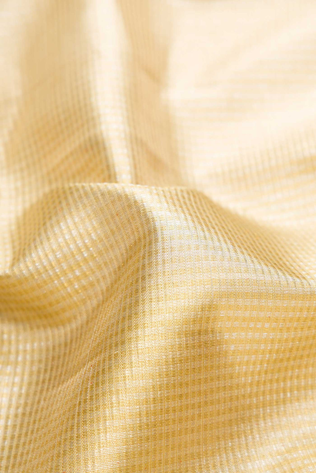 Close up of Pure Silk Pure Zari Gold Dual Tone Kanjivaram Saree with Zari Brocade on the body and Zari Border.  displaying folds