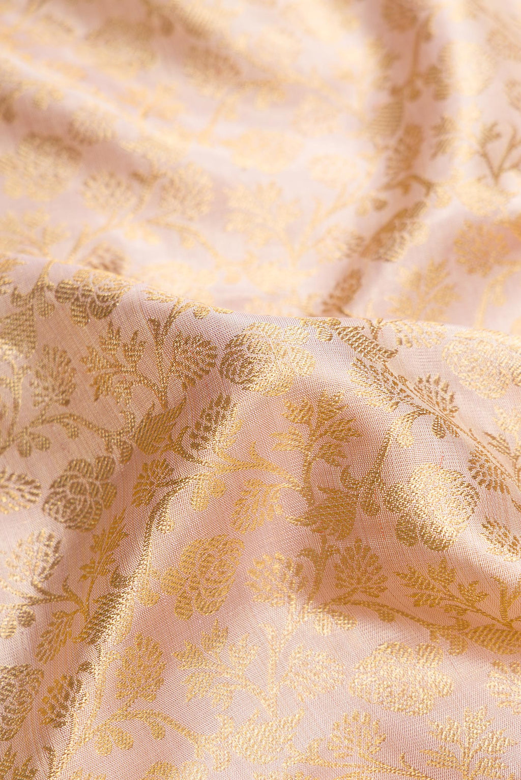 Close up of Pure Silk Pure Zari Rose Gold Dual Tone Kanjivaram Tissue Saree with Zari Brocade on the body and Zari Border.  displaying folds