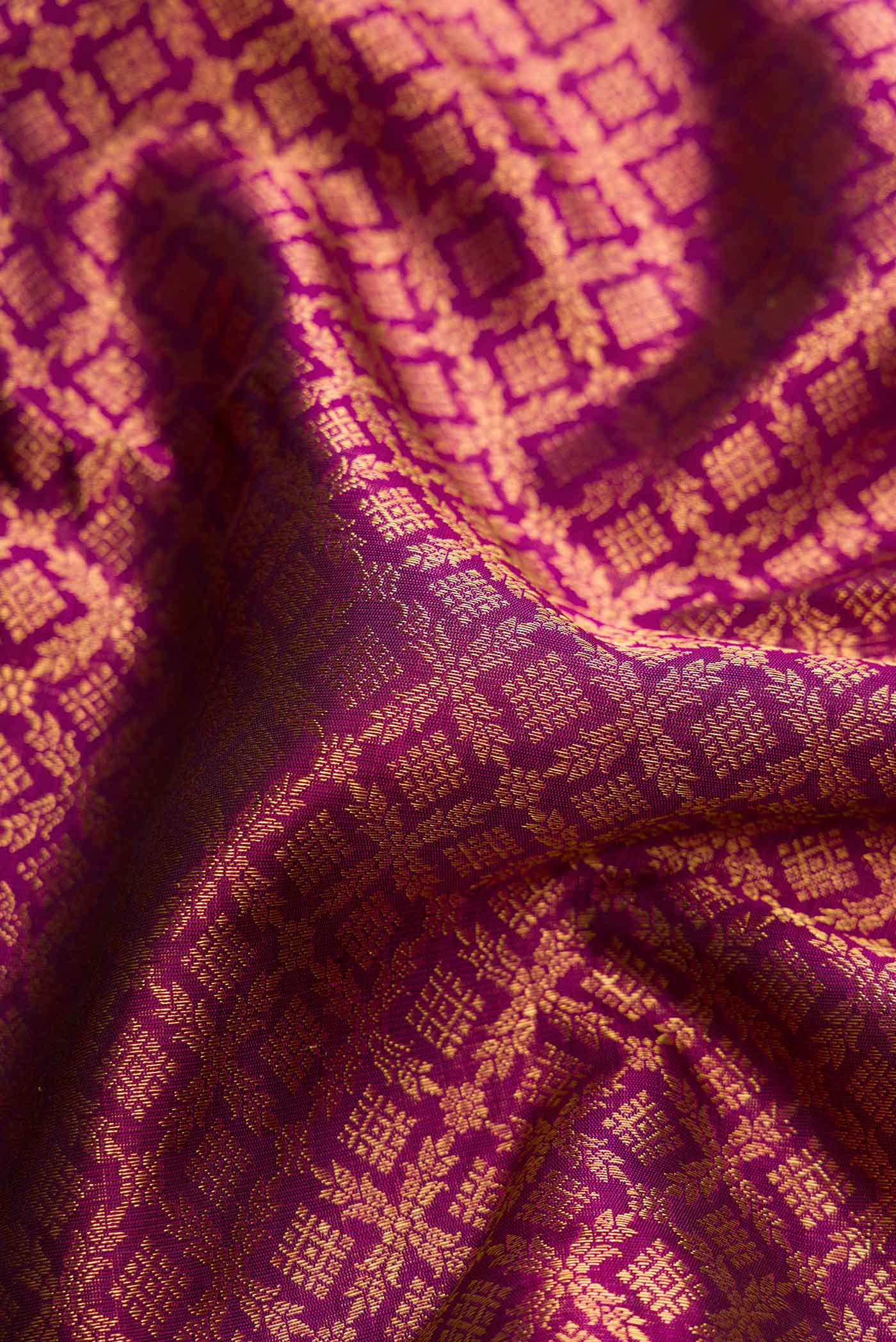 Close up of Magenta Dual Tone Kanchipuram Silk Saree with Zari Brocade on the body and Zari Border displaying folds