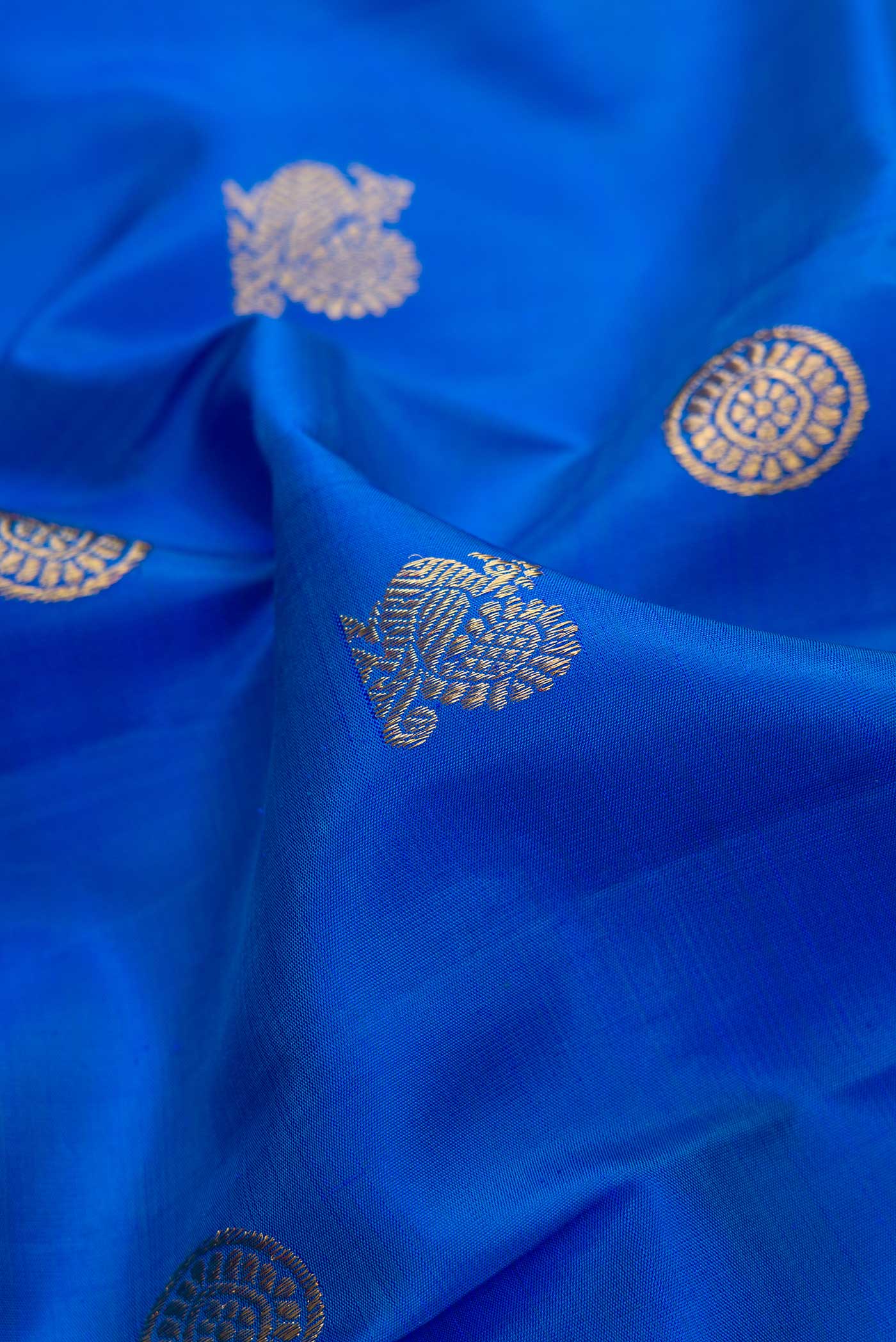 Close up of Pure Silk Pure Zari Royal Blue Dual Tone Kanjivaram Saree with Zari Butta on the body and Zari Border.  displaying folds