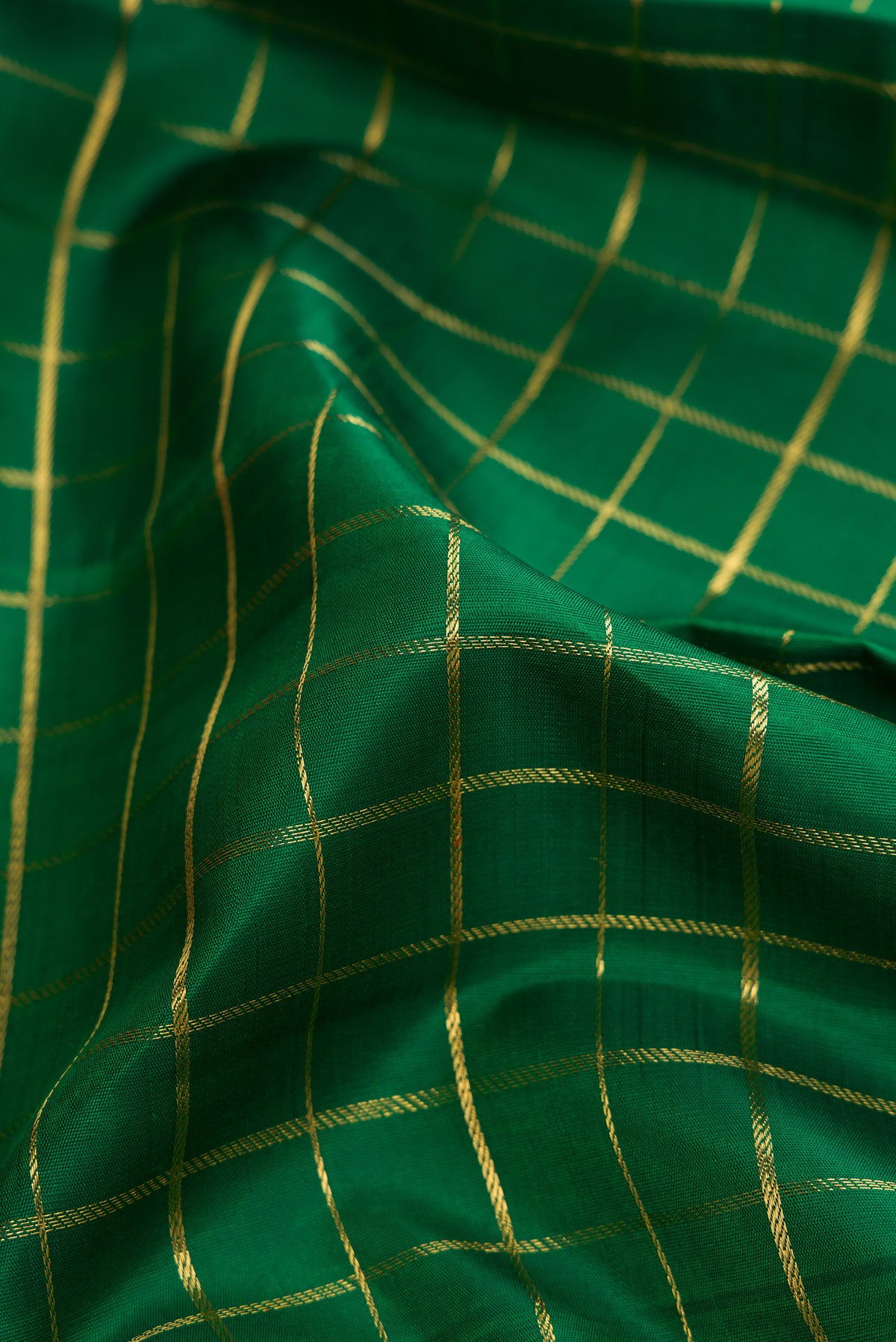 Close up of Pure Silk Pure Zari Bottle Green Dual Tone Kanjivaram Saree with Checked design on the body and Zari Border.  displaying folds