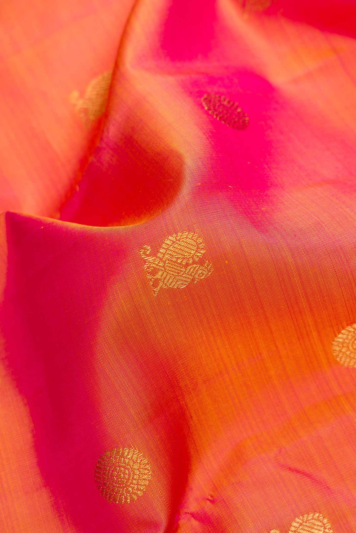 Close up of Pure Silk Pure Zari Rose Gold Dual Tone Kanjivaram Saree with Zari Butta on the body and Zari Border.  displaying folds