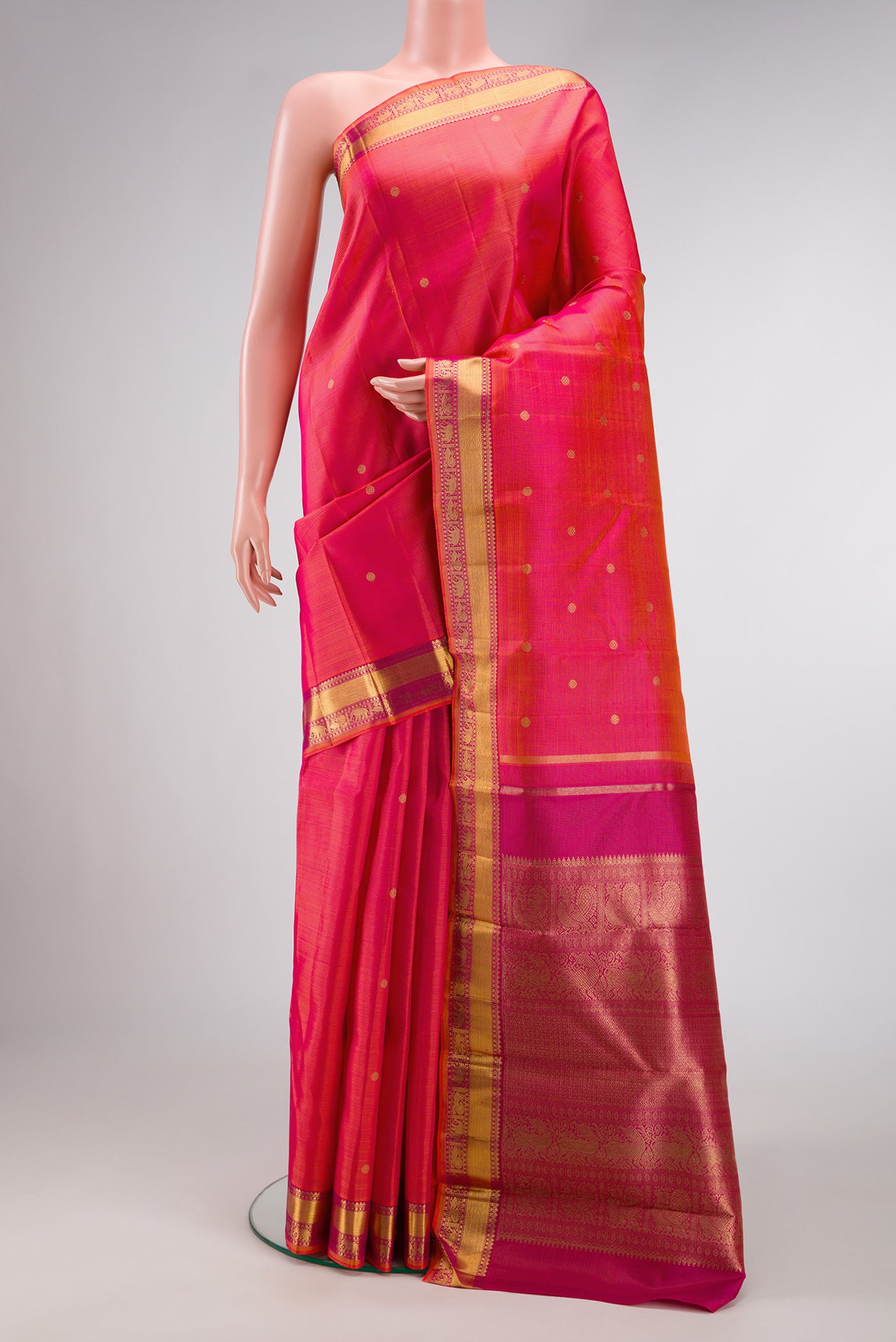 Coral Dual Tone Kanjivaram Silk Saree with Zari Butta on the body and Zari Border.  displayed on a mannequin