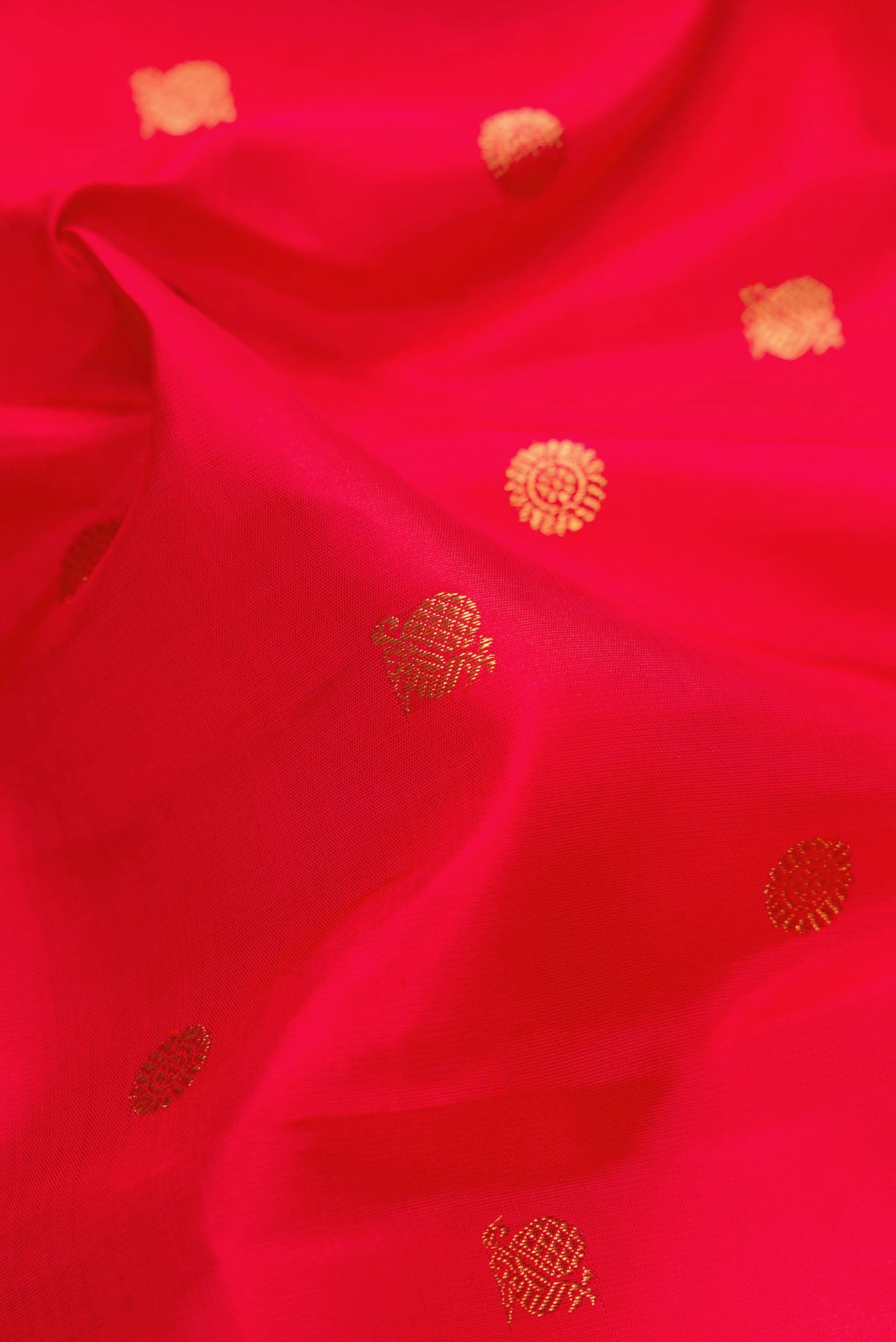 Close up of Pure Silk Pure Zari Red Dual Tone Kanchipuram Saree with Zari Butta on the body and Zari Border.  displaying folds