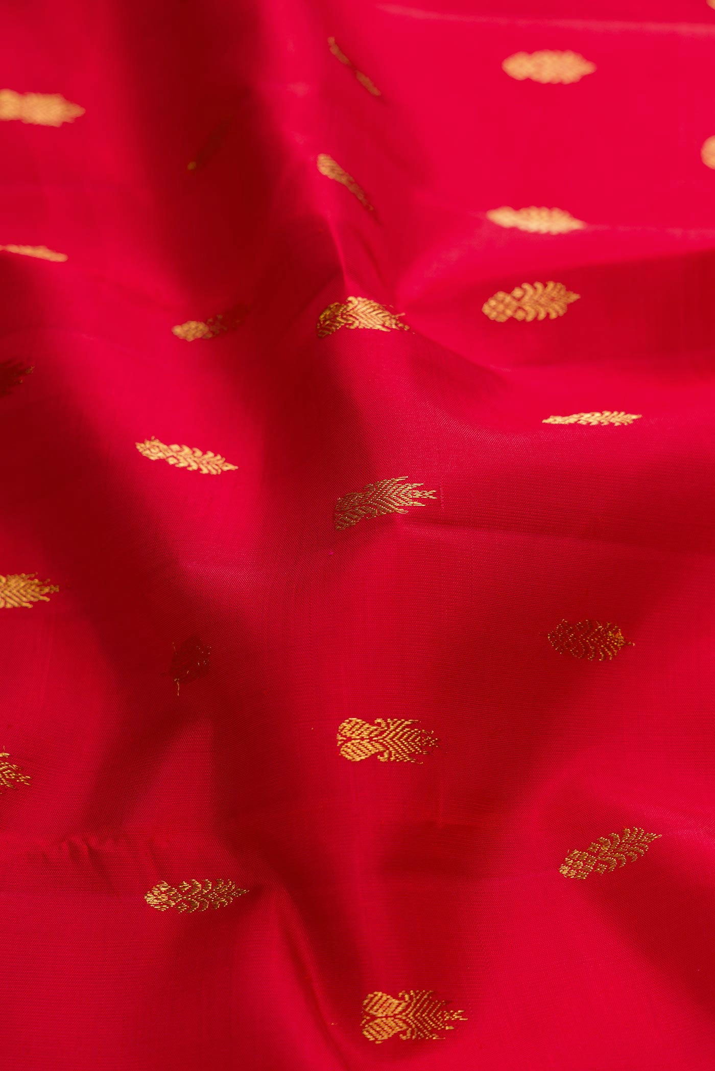 Close up of Pure Silk Pure Zari Red Dual Tone Kanchipuram Saree with Zari Butta on the body and Zari Border displaying folds