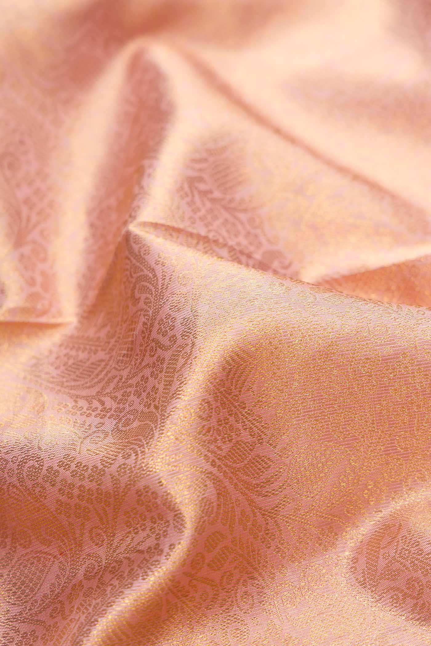 Close up of Pure Silk Pure Zari Rose Gold Kanchipuram Saree with Zari Brocade on the body and Zari Border displaying folds
