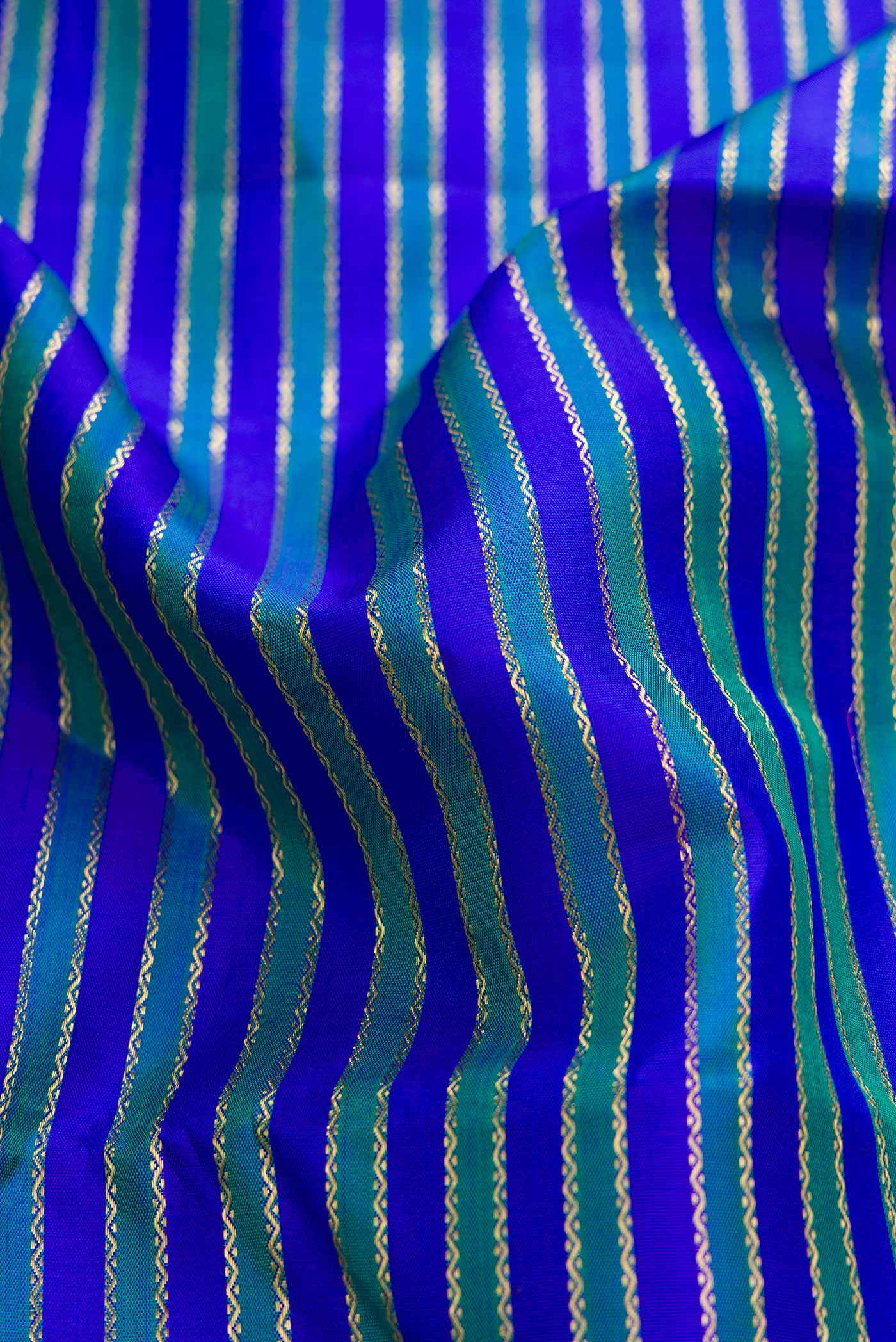 Close up of Pure Silk Pure Zari Royal Blue Dual Tone Kanchipuram Saree with Stripes on the body and Zari Border displaying folds