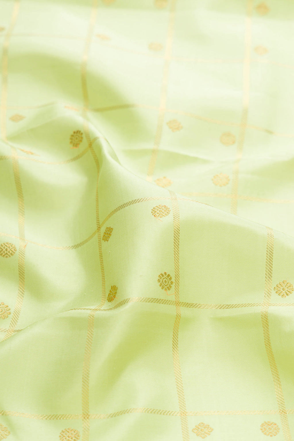 Close up of Pure Silk Pure Zari Parrot Green Dual Tone Kanchipuram Saree with Checked design on the body and Zari Border displaying folds