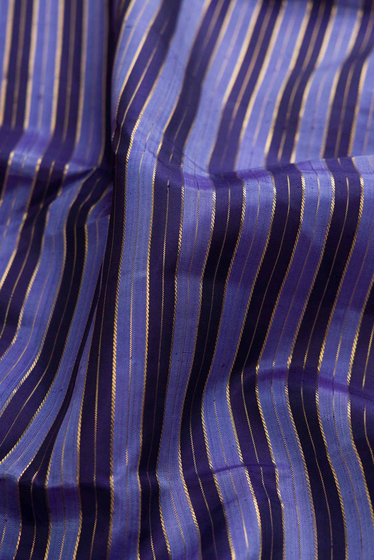 Close up of Pure Silk Pure Zari Blue Dual Tone Kanchipuram Saree with Stripes on the body and Zari Border displaying folds