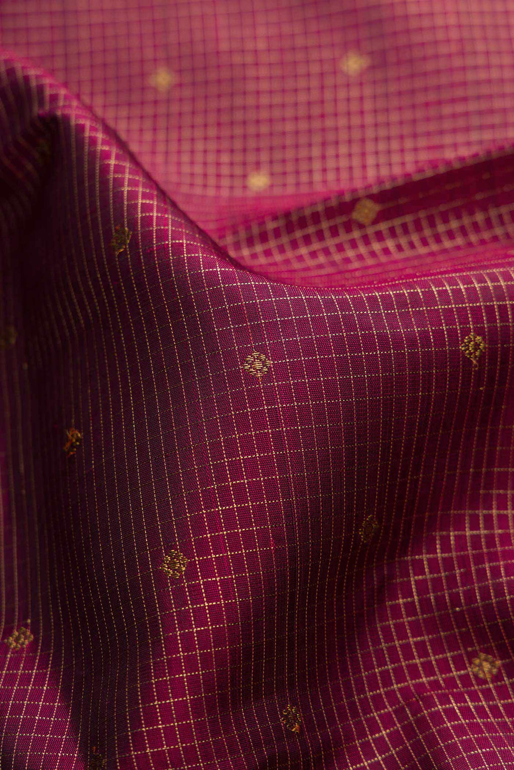 Close up of Pure Silk Pure Zari Maroon Dual Tone Kanchipuram Saree with Zari Butta on the body and Zari Border displaying folds