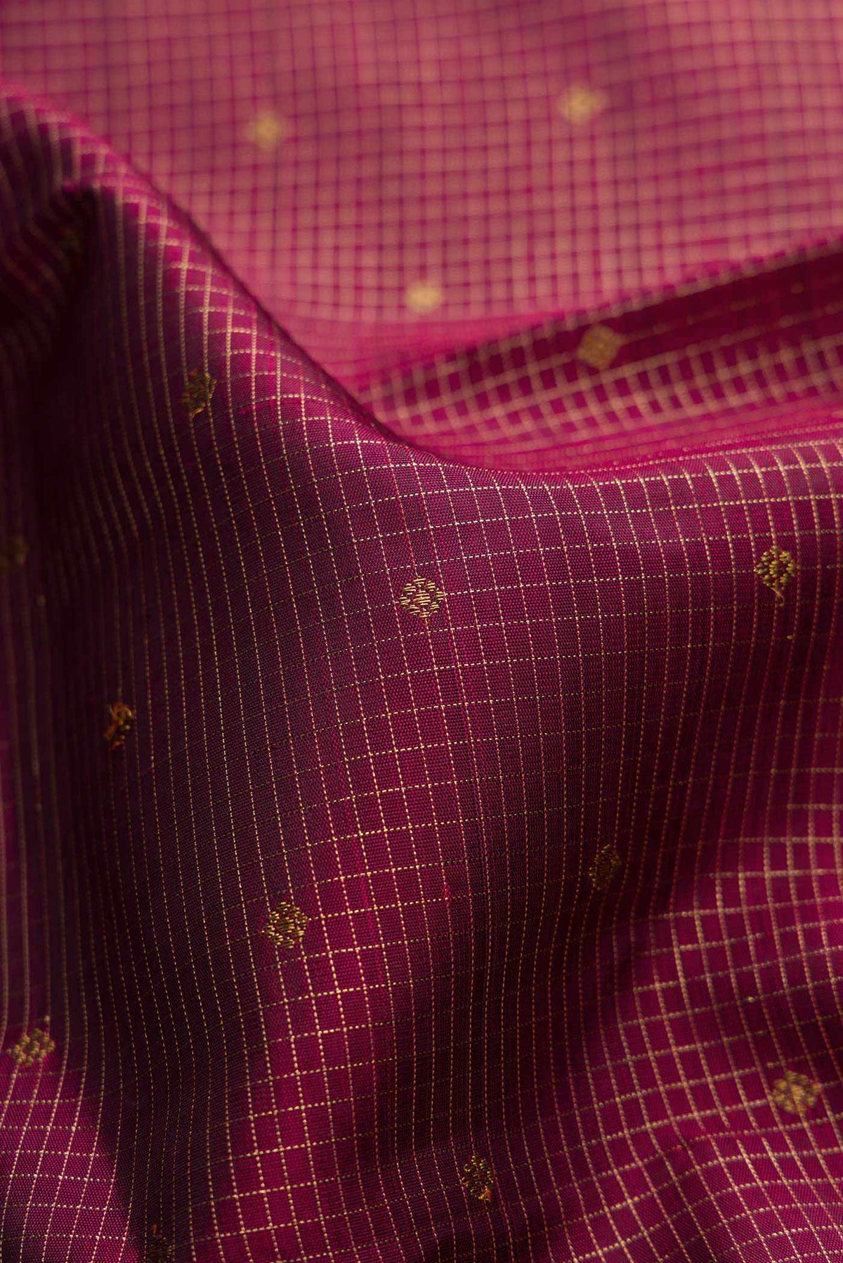 Close up of Pure Silk Pure Zari Maroon Dual Tone Kanchipuram Saree with Zari Butta on the body and Zari Border displaying folds