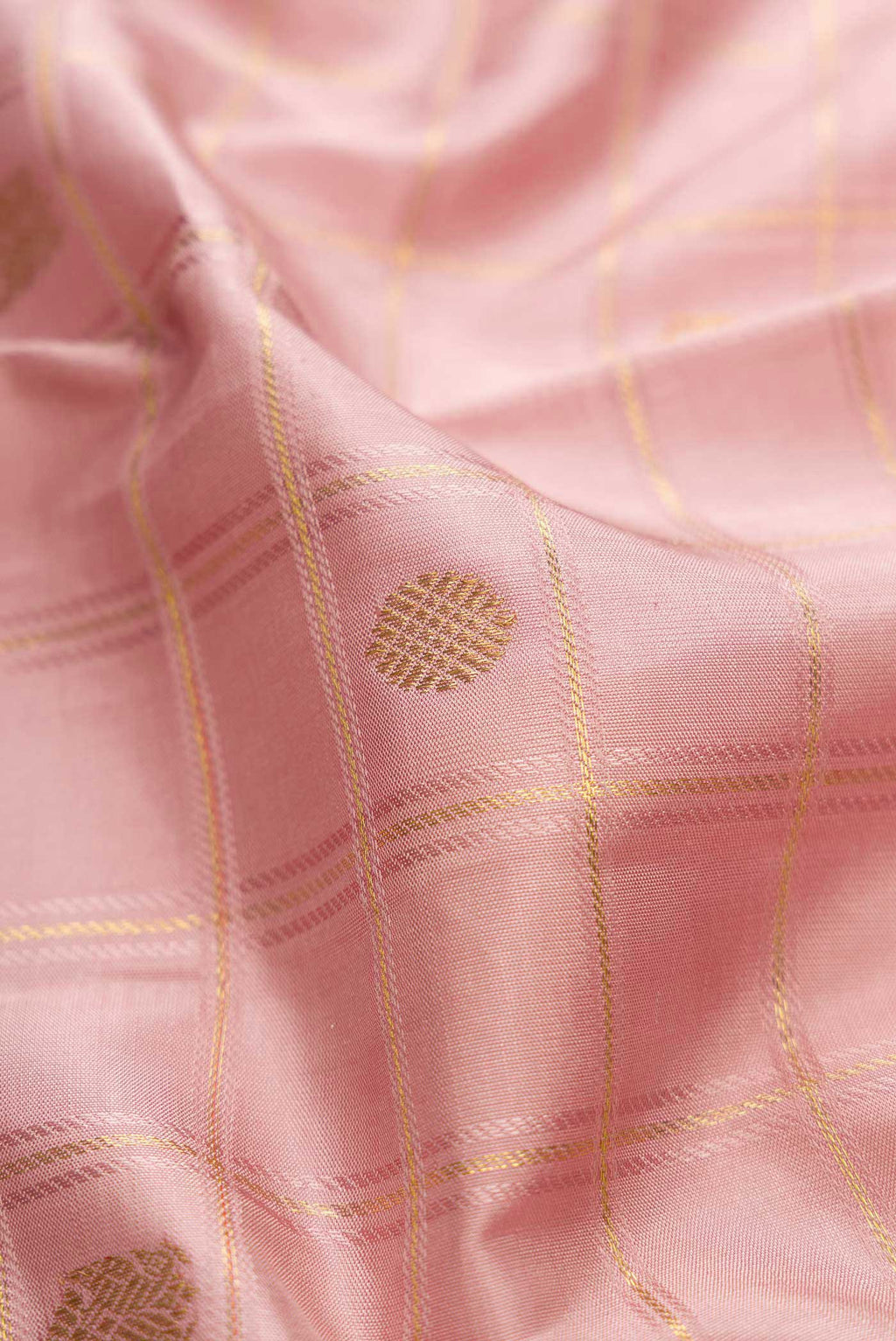 Close up of Pure Silk Pure Zari Rose Gold Dual Tone Kanchipuram Saree with Checked design on the body and Zari Border displaying folds