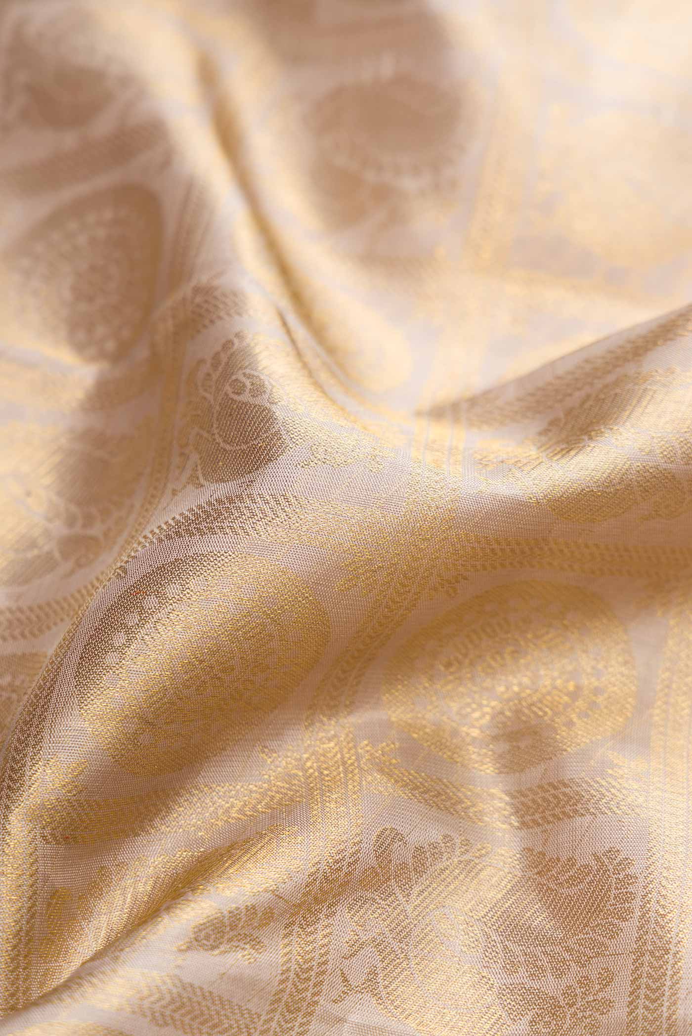 Close up of Pure Silk Pure Zari Beige Dual Tone Kanchipuram Saree with Zari Brocade on the body and Zari Border displaying folds