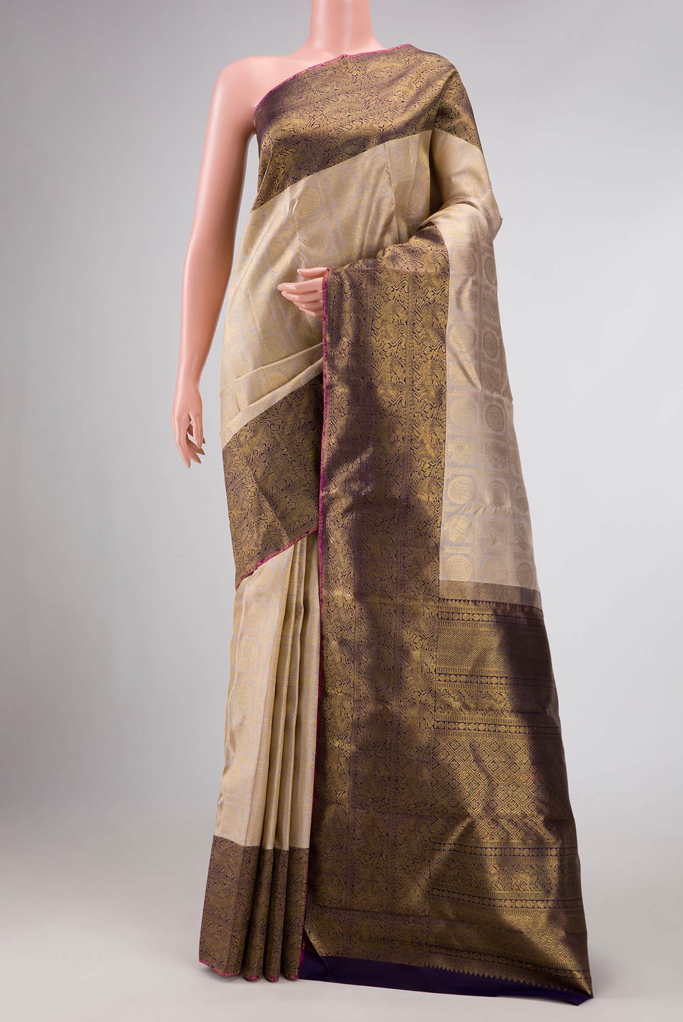 Pure Silk Pure Zari Beige Dual Tone Kanchipuram Saree with Zari Brocade on the body and Zari Border displayed on a mannequin