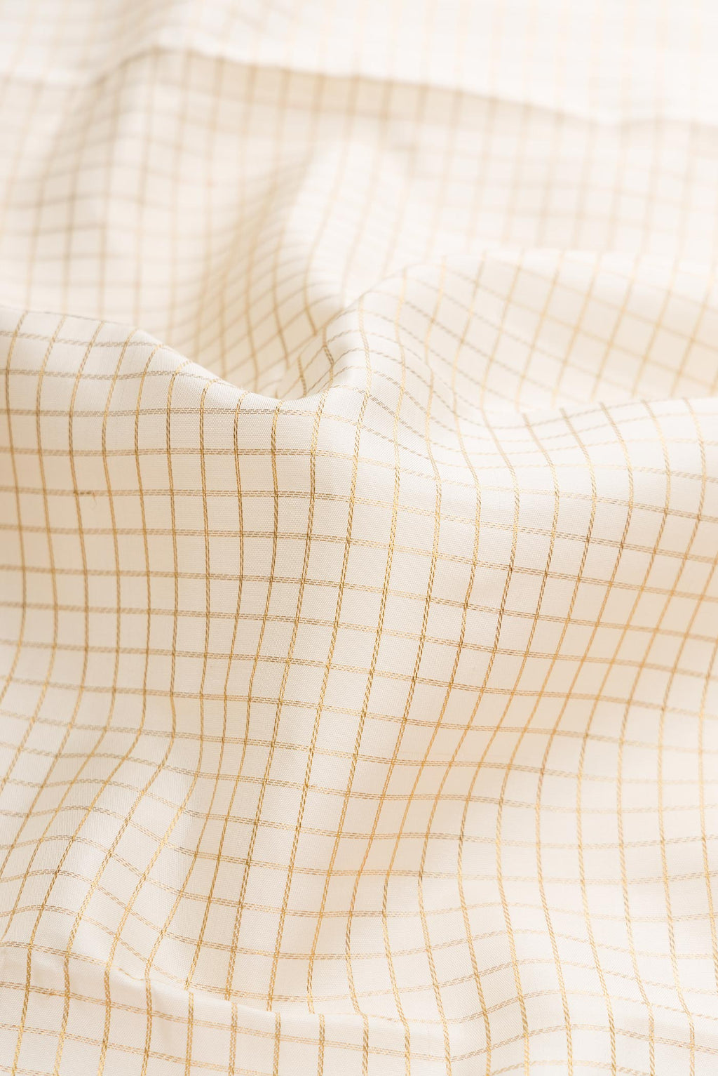 Close up of Pure Silk Pure Zari Off White Dual Tone Kanchipuram Saree with Checked design on the body and Zari Border displaying folds