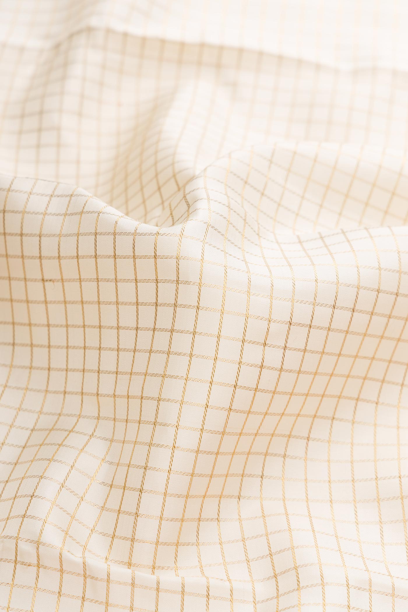 Close up of Pure Silk Pure Zari Off White Dual Tone Kanchipuram Saree with Checked design on the body and Zari Border displaying folds