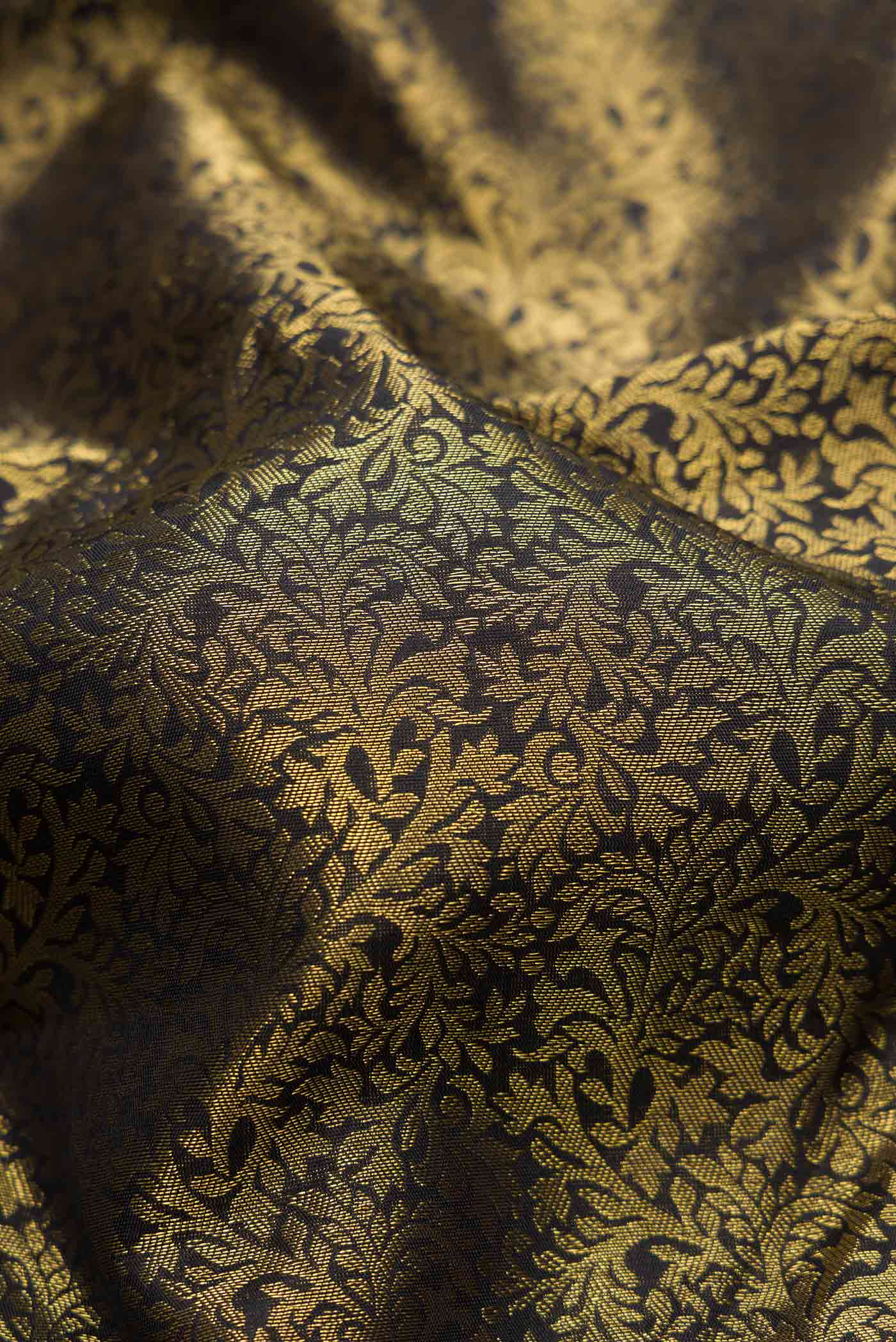 Close up of Pure Silk Pure Zari Black Dual Tone Kanjivaram Tissue Saree with Zari Brocade on the body and Zari Border.  displaying folds
