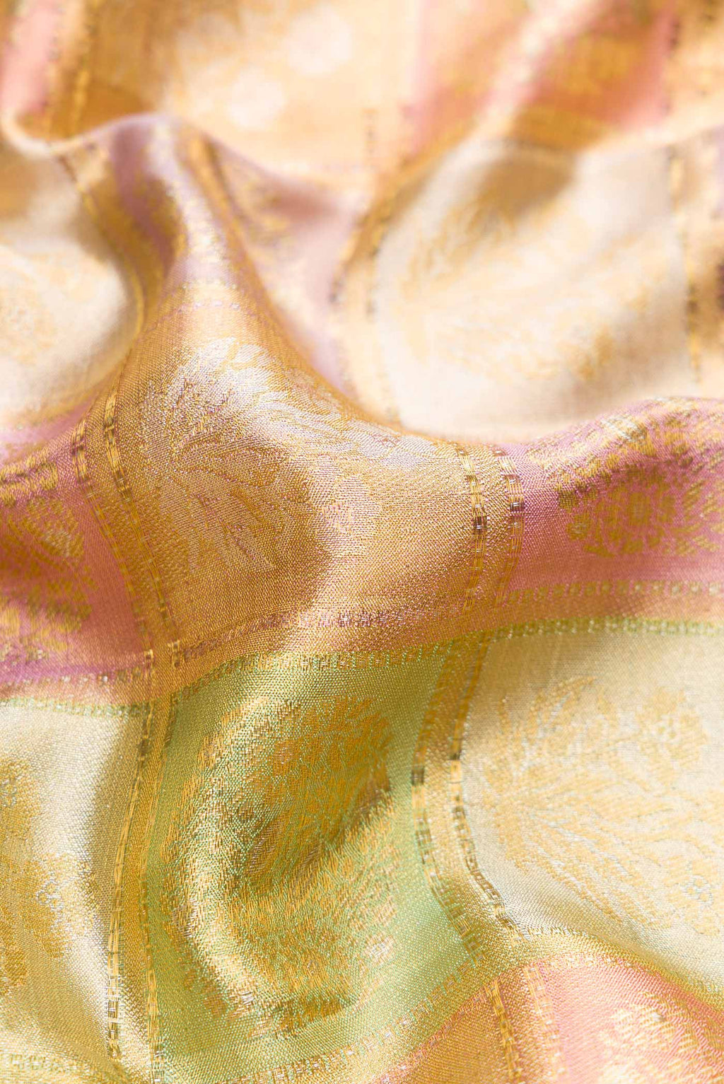 Close up of Gold, Sea Green, Pink and Purple Color Kanjivaram Tissue Silk Saree with Zari Brocade on the body and Zari Border.  displaying folds
