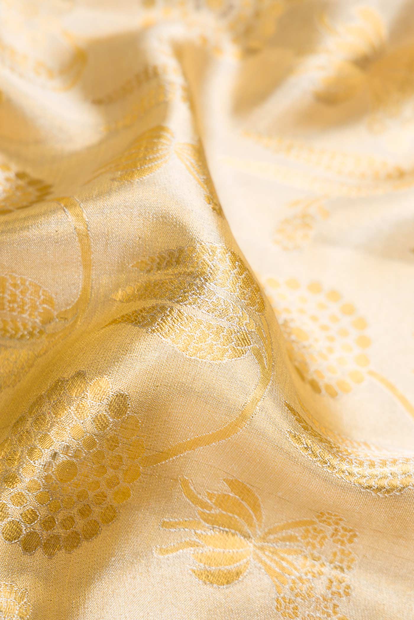 Close up of Gold Dual Tone Kanjivaram Tissue Silk Saree with Zari Brocade on the body and Fancy Border.  displaying folds
