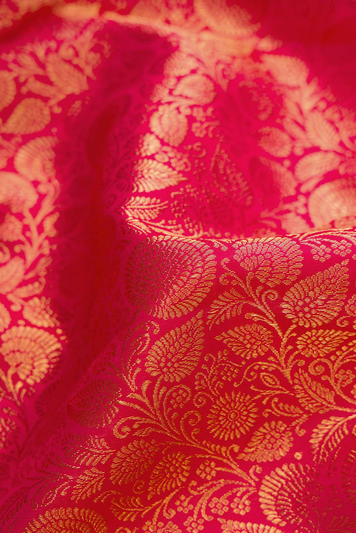 Close up of Pure Silk Pure Zari Dark Pink Dual Tone Kanchipuram Saree with Zari Brocade on the body and Zari Border displaying folds