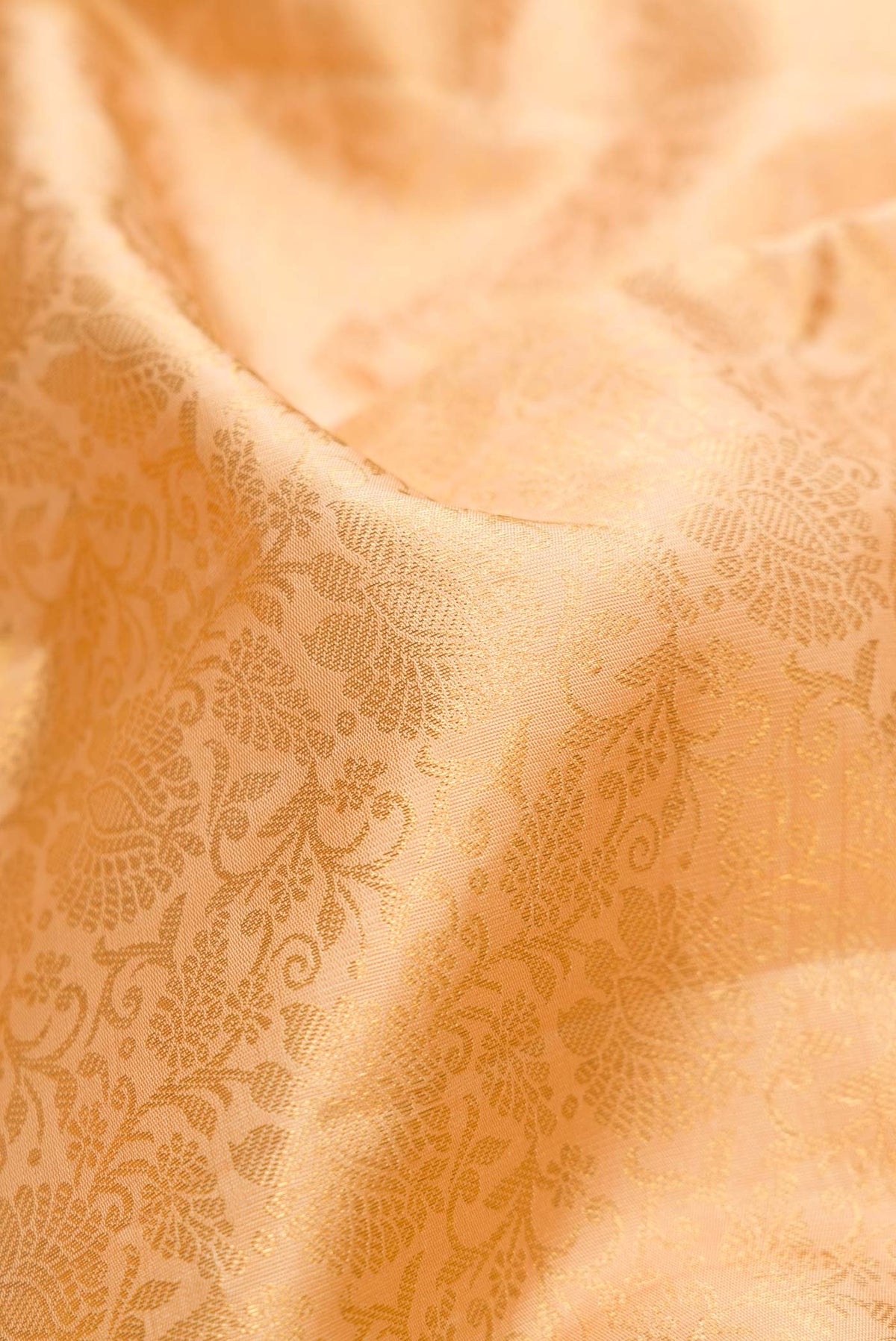 Close up of Pure Silk Pure Zari Golden Peach Dual Tone Kanchipuram Saree with Zari Brocade on the body and Zari Border displaying folds