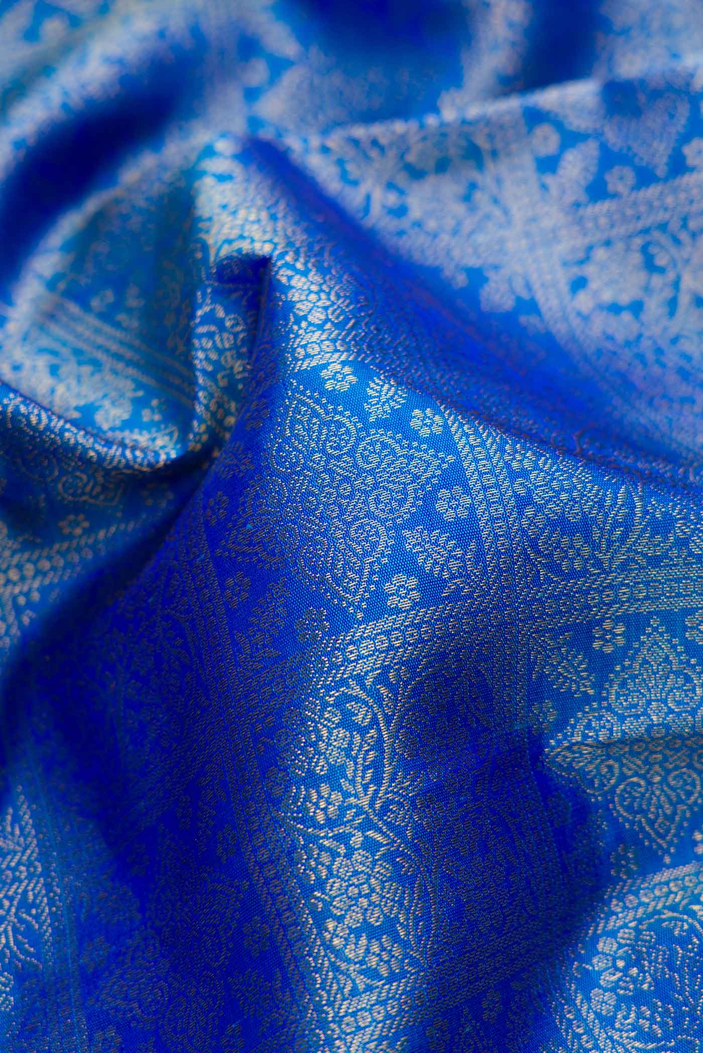 Close up of Pure Silk Pure Zari Peacock Blue Dual Tone Kanchipuram Saree with Zari Brocade on the body and Zari Border displaying folds